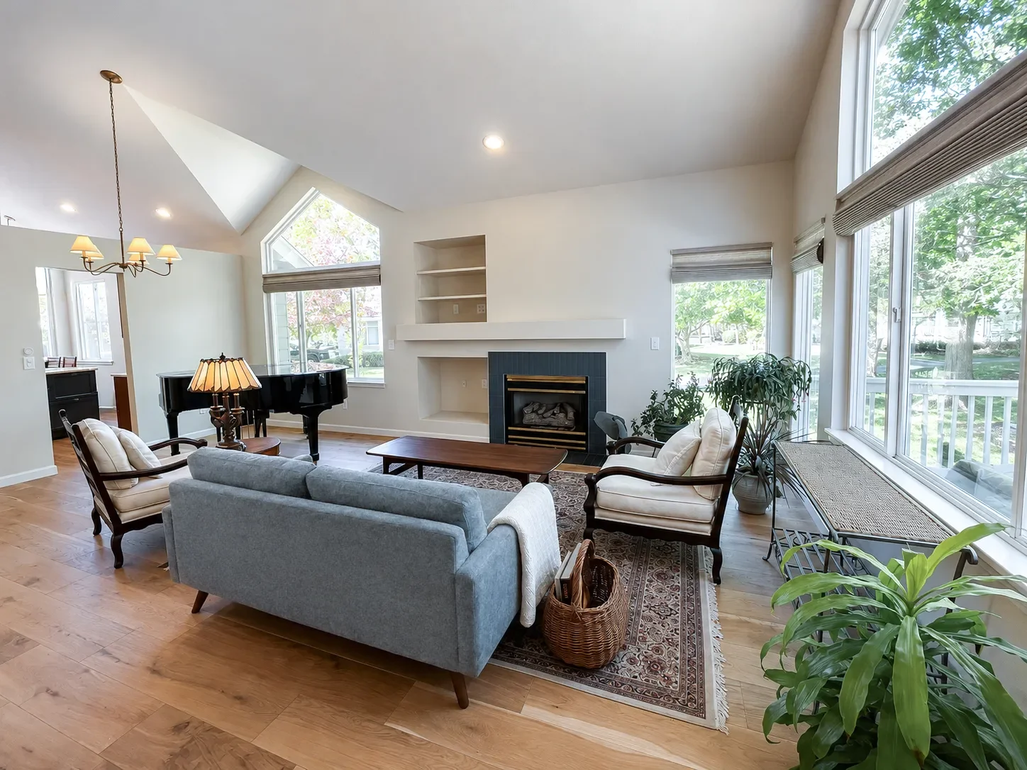 Living room view of a Gunbarrel full craftsman home remodel featuring newly tiled fireplace and oak hardwood floors with vaulted ceilings and natural light