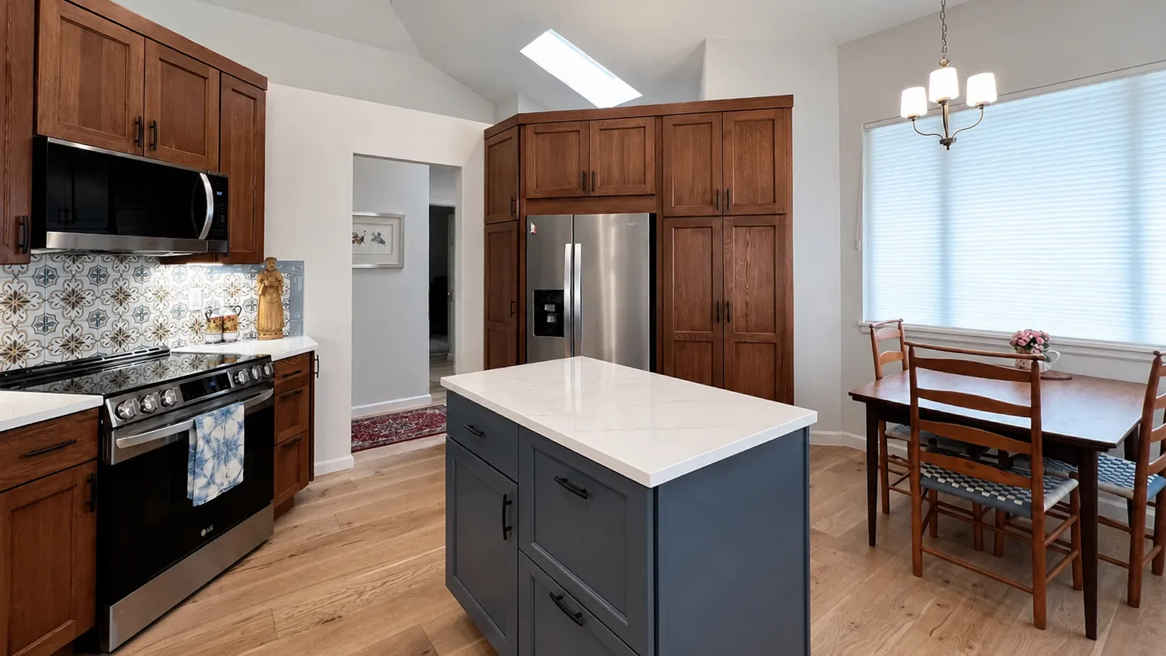 Gunbarrel, CO completed contemporary craftsman kitchen remodel with cherry wood custom cabinets, blue mobile kitchen island, white quartz countertops, and blue patterned tile backsplash