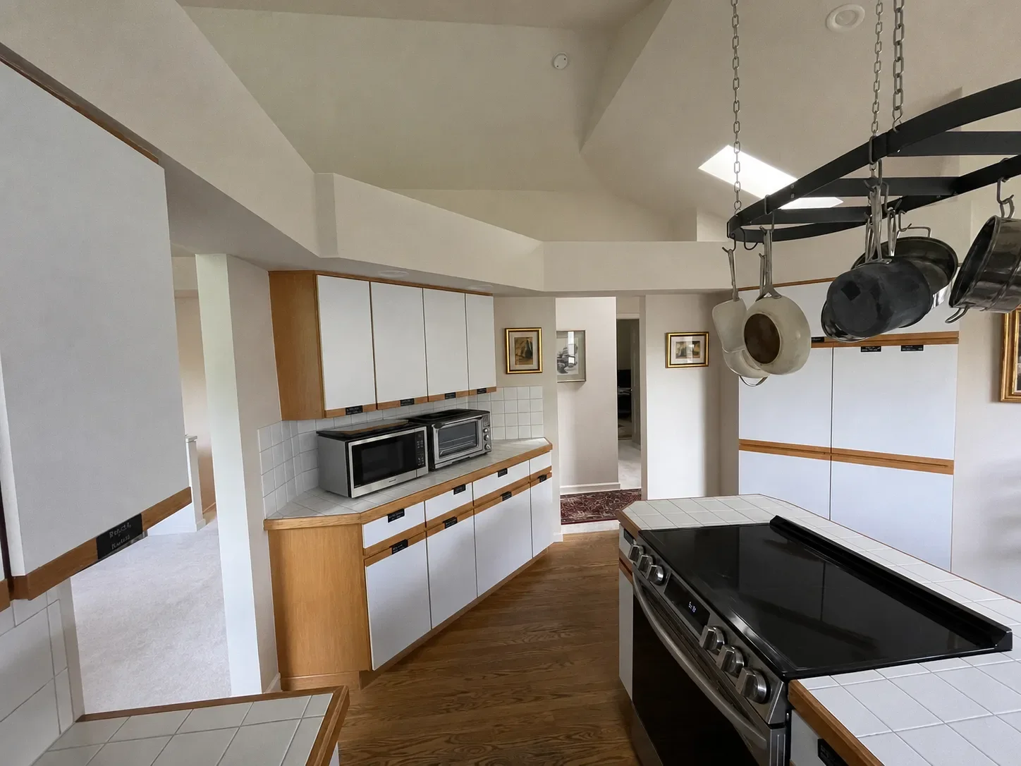 View of kitchen in Gunbarrel, CO before remodel showcasing honey wood cabinets with white doors and limited counter space