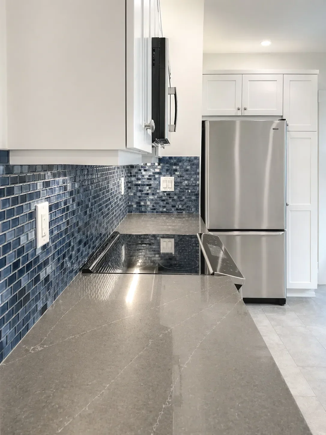 Lafeyette, CO coastal contemporary kitchen remodel overlooking blue glass mosaic tile backsplash