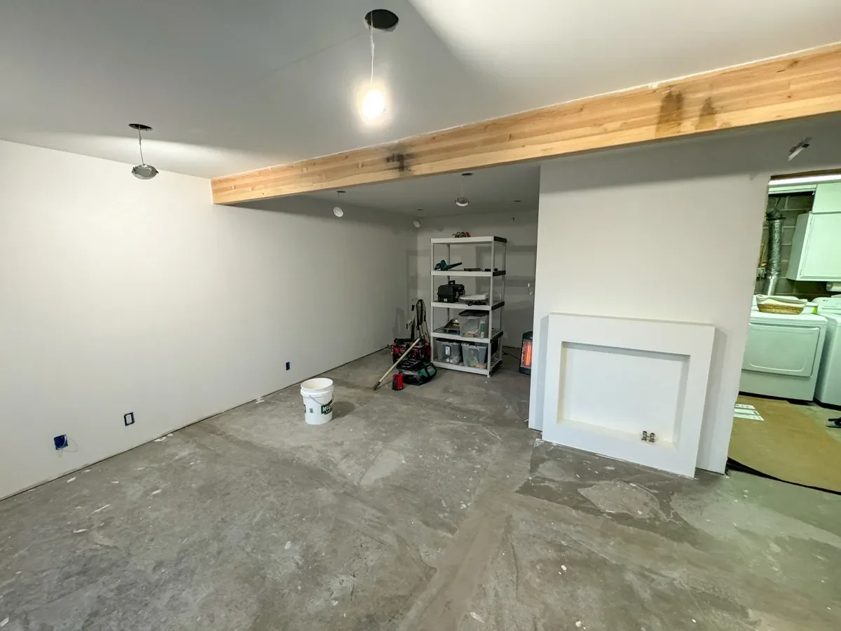 Unfinished basement remodel progress in Boulder, CO showcasing smooth finished white drywall and exposed ceiling beam
