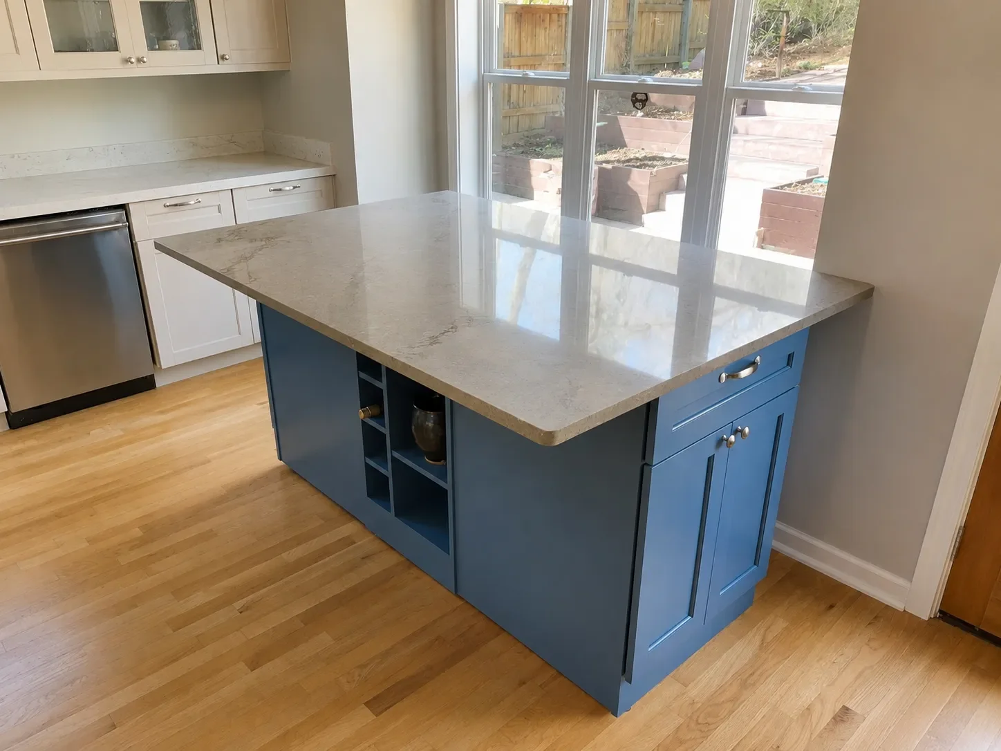 Blue custom kitchen cabinet island in Superior, CO with gray quartz countertop, 12" overhang for seating, built-in shelves, and additional kitchen cabinet storage