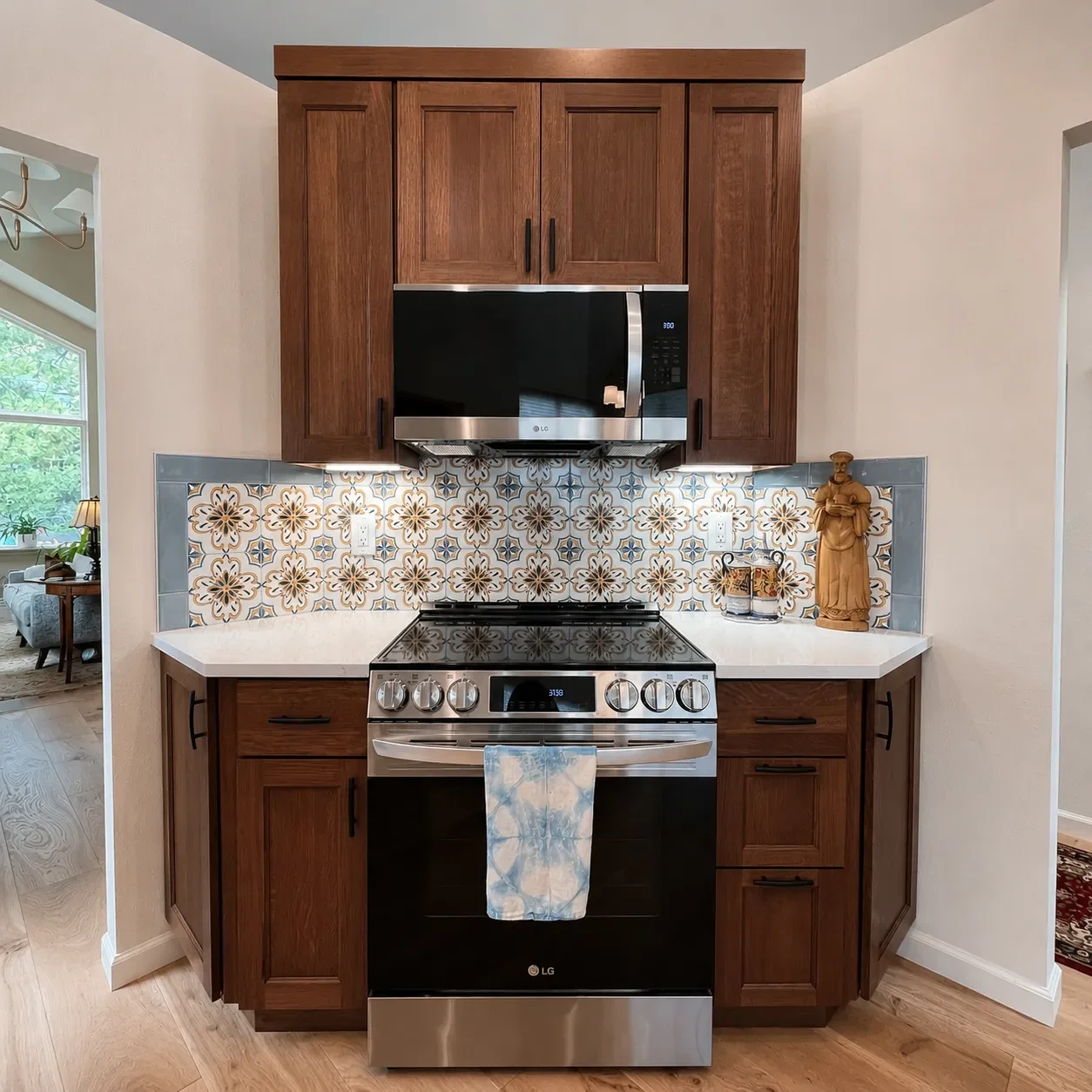 Stainless Steel glass top stove and microwave set in custom cherry wood quartz top cabinets with pattern tile backsplash in a Contemporary Craftsman kitchen remodel in Gunbarrel, CO 
