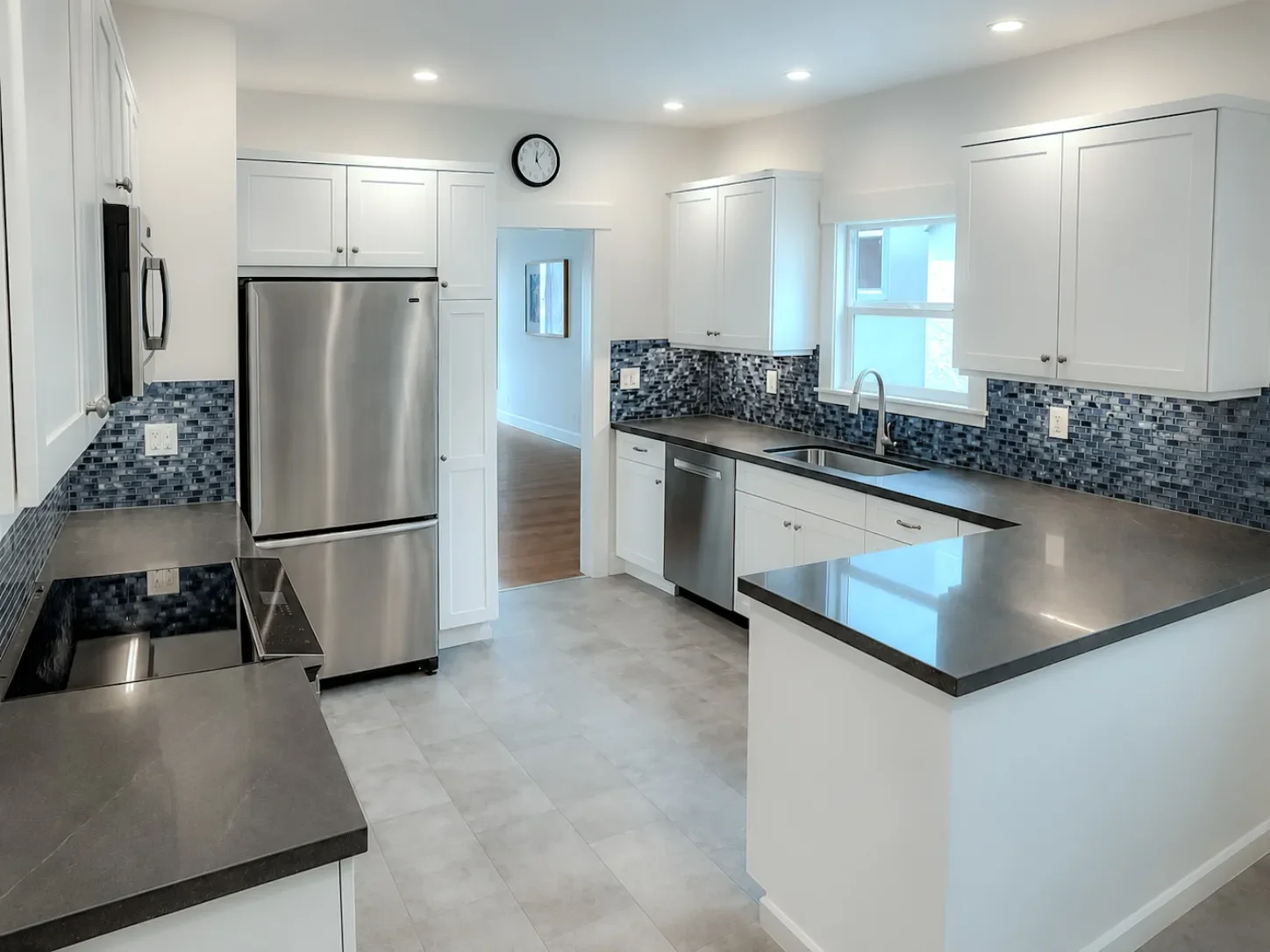 Blue contemporary kitchen with white cabinets and upgraded recessed lighting throughout the kitchen, remodeled in Lafayette, CO