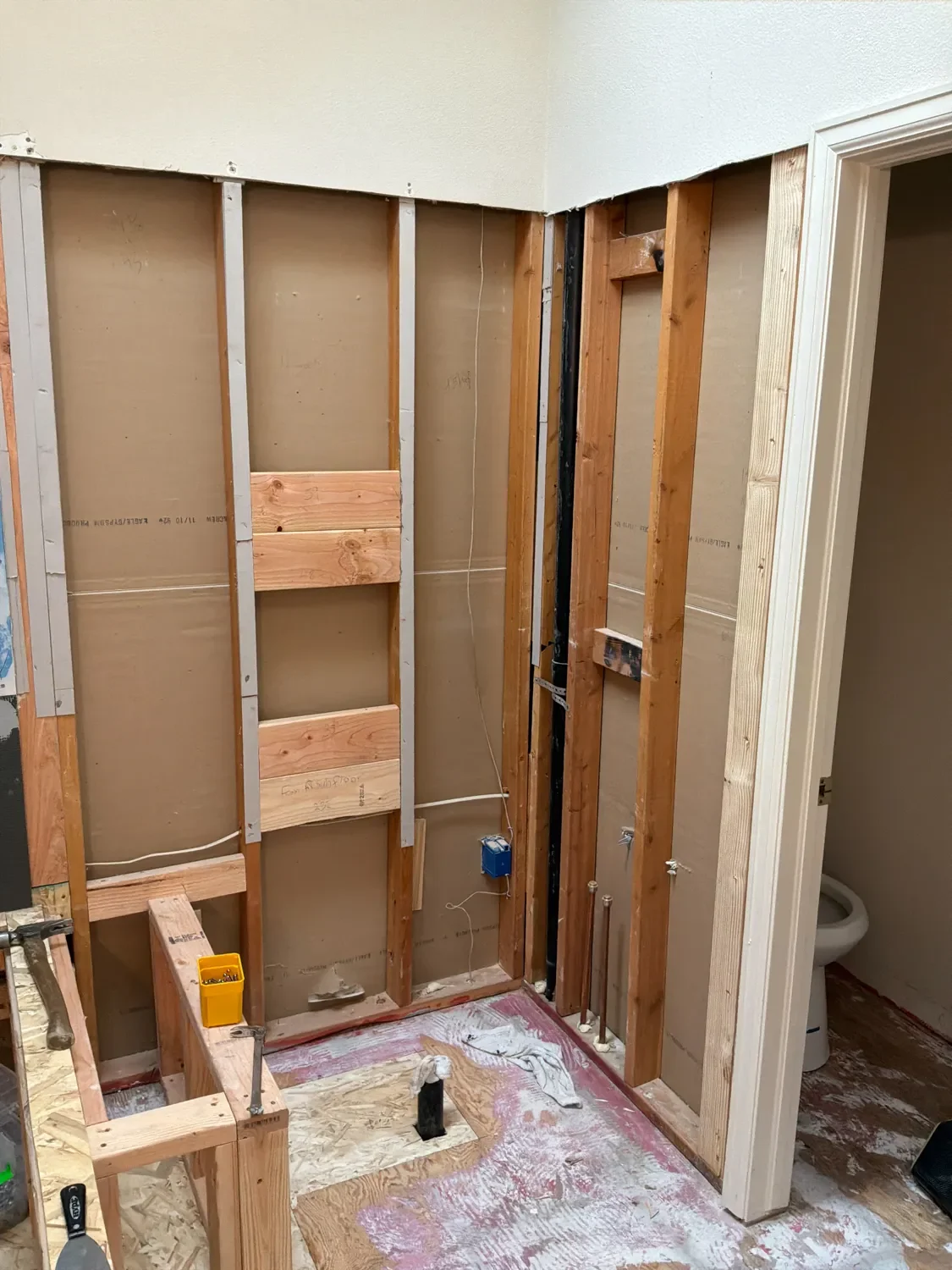 Bathroom remodel in progress featuring shower framing with built-in shower bench seat, exposed unfinished walls in Gunbarrel, CO