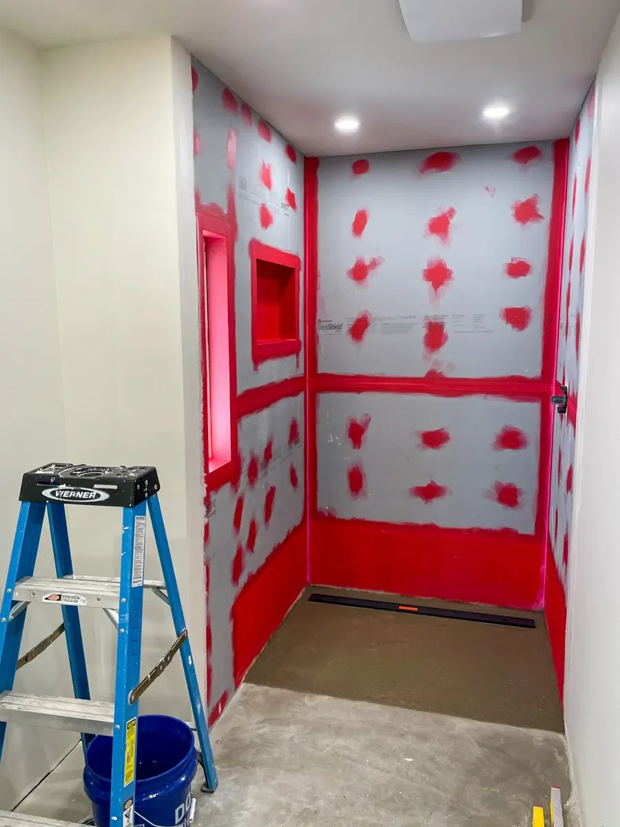 View of shower in Superior, CO unfinished bathroom remodel showcasing freshly sealed drywall panels around new cut-out window and recessed niche