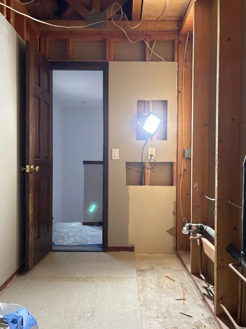  Bathroom renovation in progress with exposed wall framing and newly finished floor and vanity demo in Table Mesa, Boulder, CO