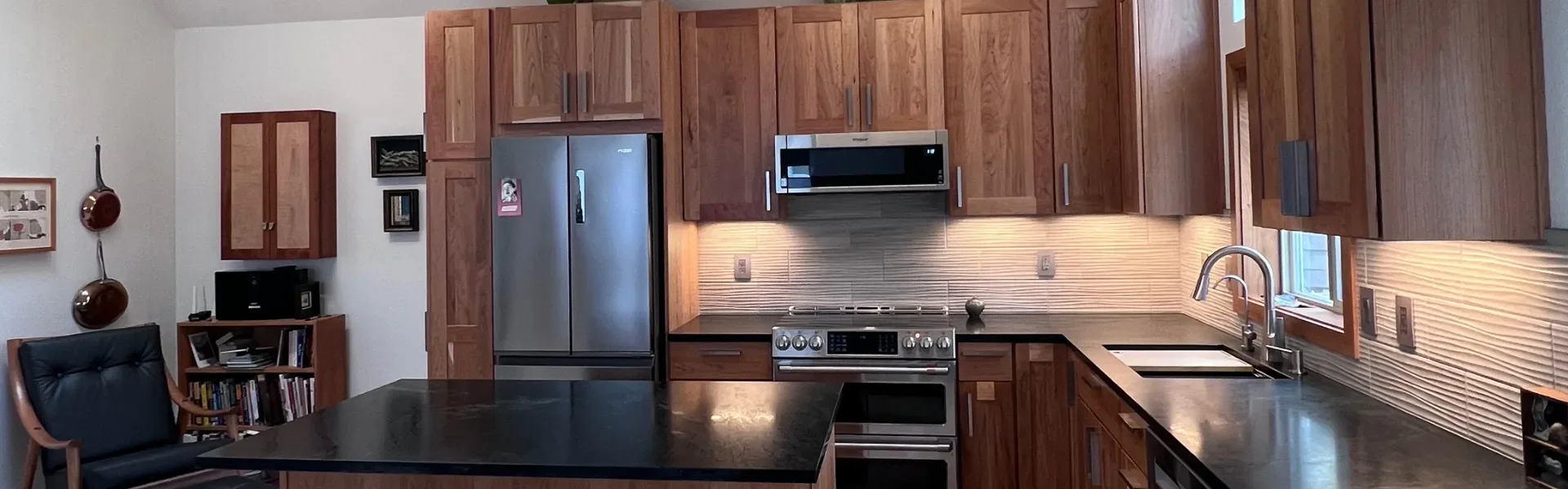 Wide angle banner view of Newlands Boulder, CO contemporary craftsman kitchen remodel with cherry wood cabinetry, dark green stone countertops, and green accent decor