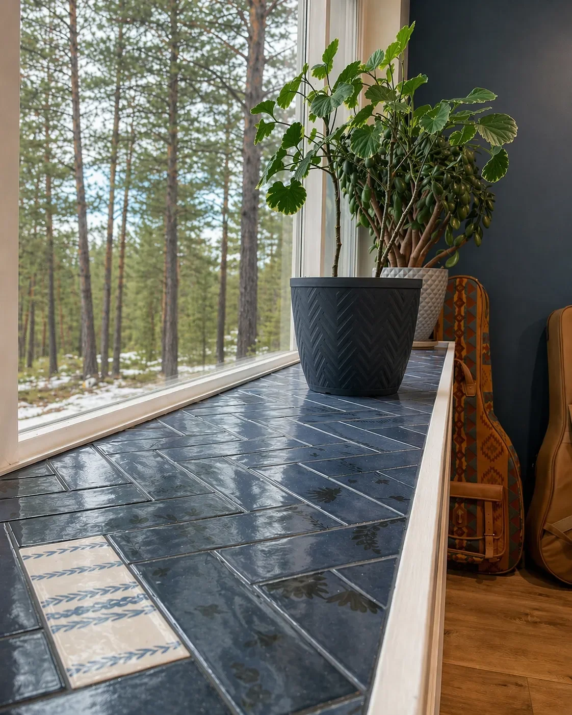 Close up detail view of blue herringbone tiled window ledge with plants and mountain views in a finished basement remodel by Downy Home Remodeling