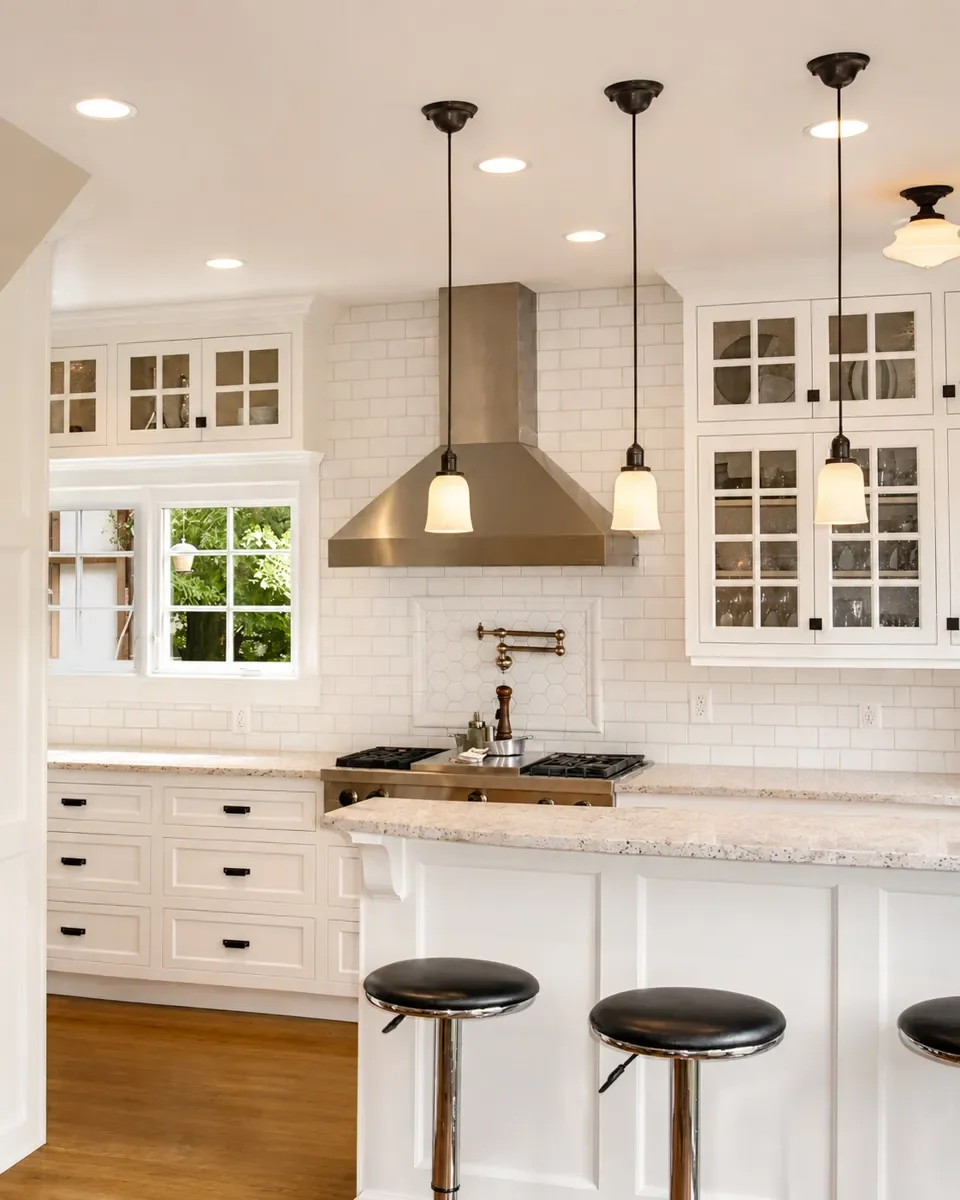 Tudor farmhouse kitchen remodel in Mapleton Hill, Boulder, CO showcasing how Downy Home Remodeling preserved the home's historic architecture while building new custom white cabinets and barstool seating peninsula