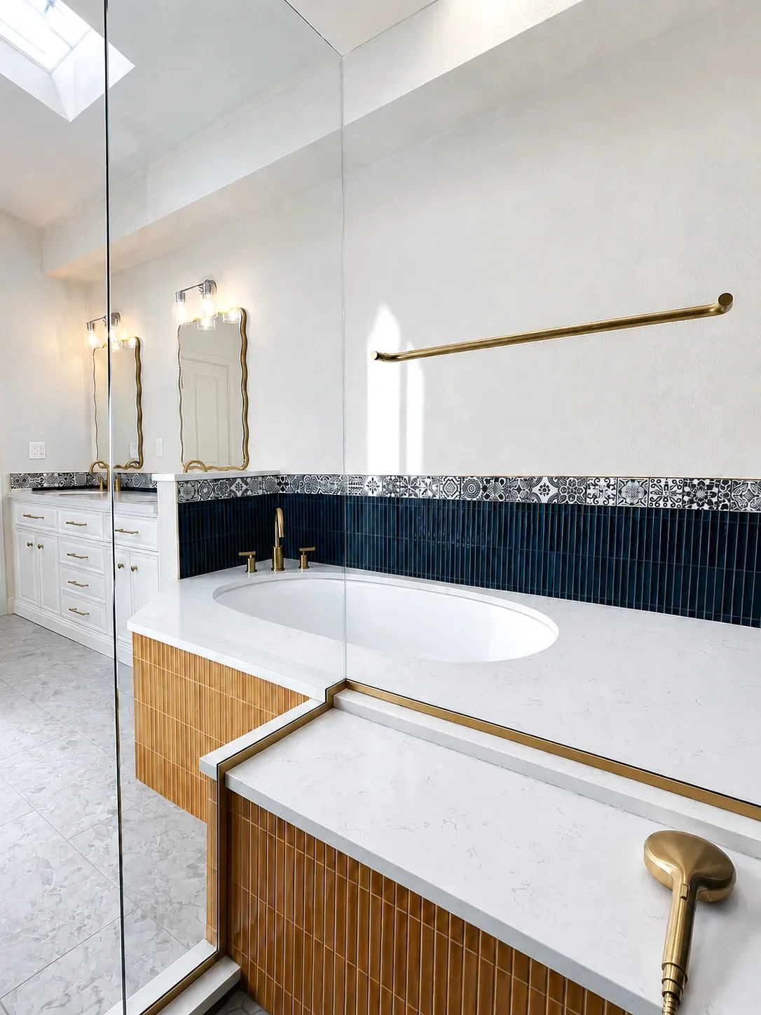 Contemporary art deco luxury master bathroom remodel by Downy Home Remodeling in Boulder, CO featuring seated shower, quartz counter soaking tub, vaulted ceilings, skylights, and white walls with contrasting bold blue and yellow tile wainscoting