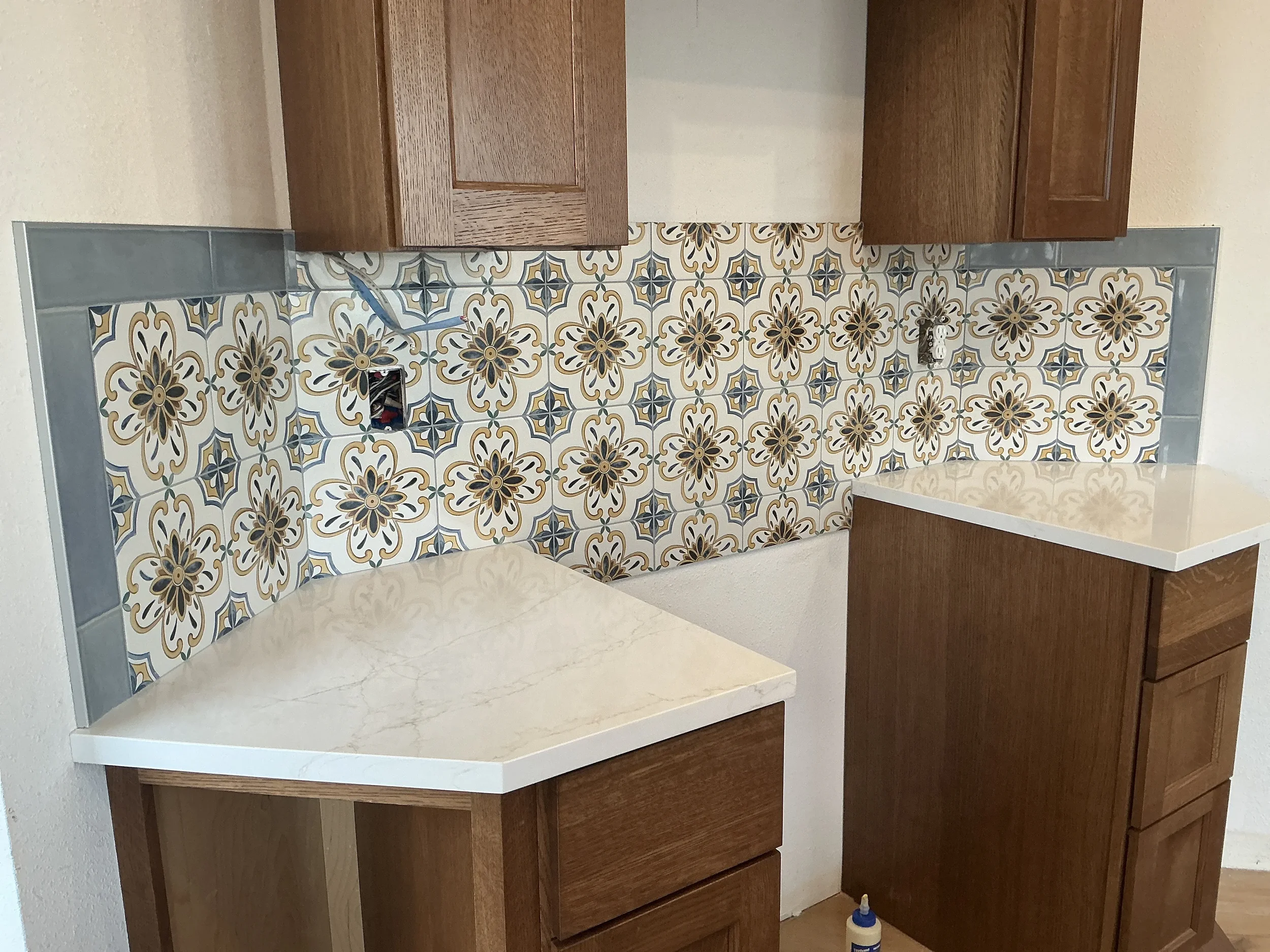 Kitchen remodel in progress in Gunbarrel, CO featuring pattern tile backsplash with light blue subway tile trim and white quartz countertops 