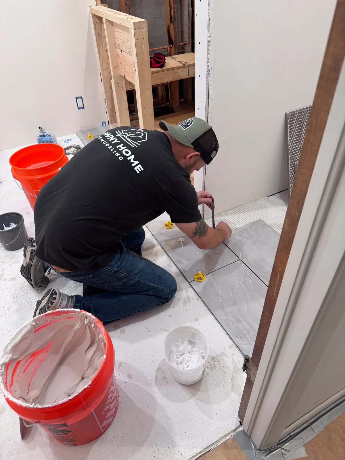 Floor tile mudding and install in a bathroom remodel under construction by Downy Home Remodeling in Boulder, CO