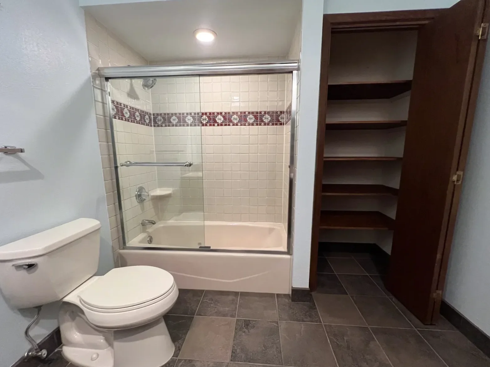 outdated vintage bathroom with sliding glass combination shower bathtub and deeply recessed shelf storage linen closet in a Boulder, CO bathroom before being remodeled