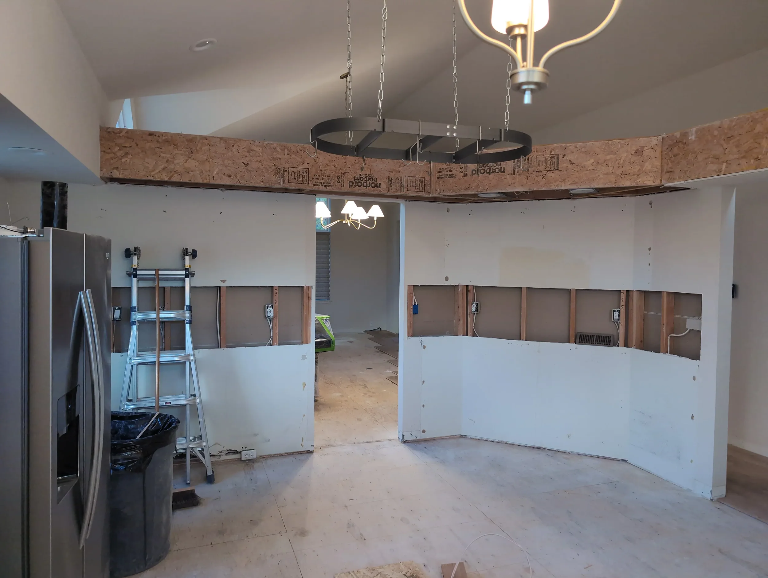 Kitchen remodel in progress in Gunbarrel, CO featuring exposed soffit, removed floors and cabinets, and sanded subfloor
