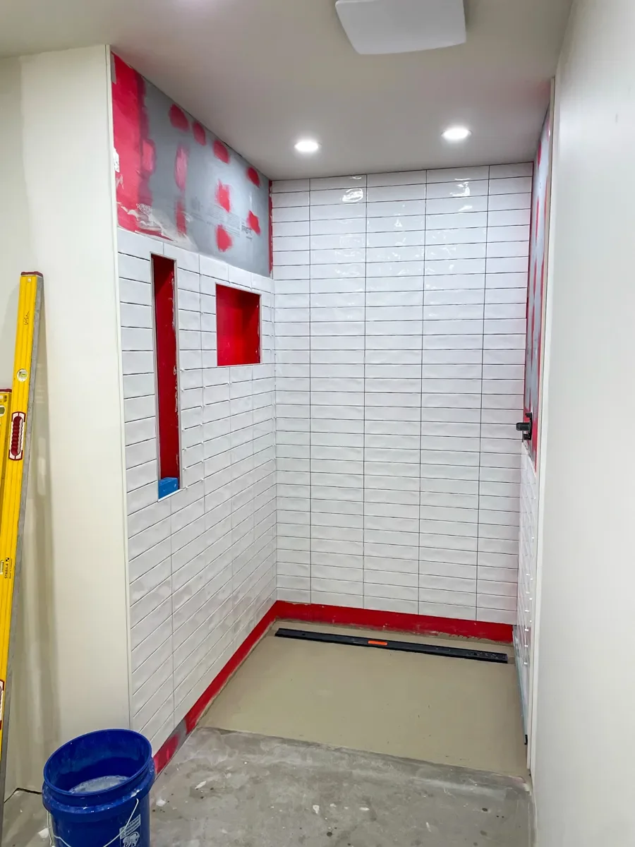 Bathroom remodeling construction featuring partially tiled curbless shower with channel floor drain in Superior, CO