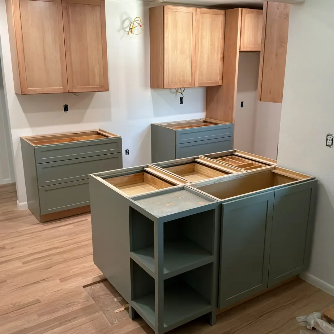 New two-tone natural maple upper shaker style cabinets and green lower cabinets in a kitchen remodel in progress in Longmont, CO, still awaiting countertop installation.