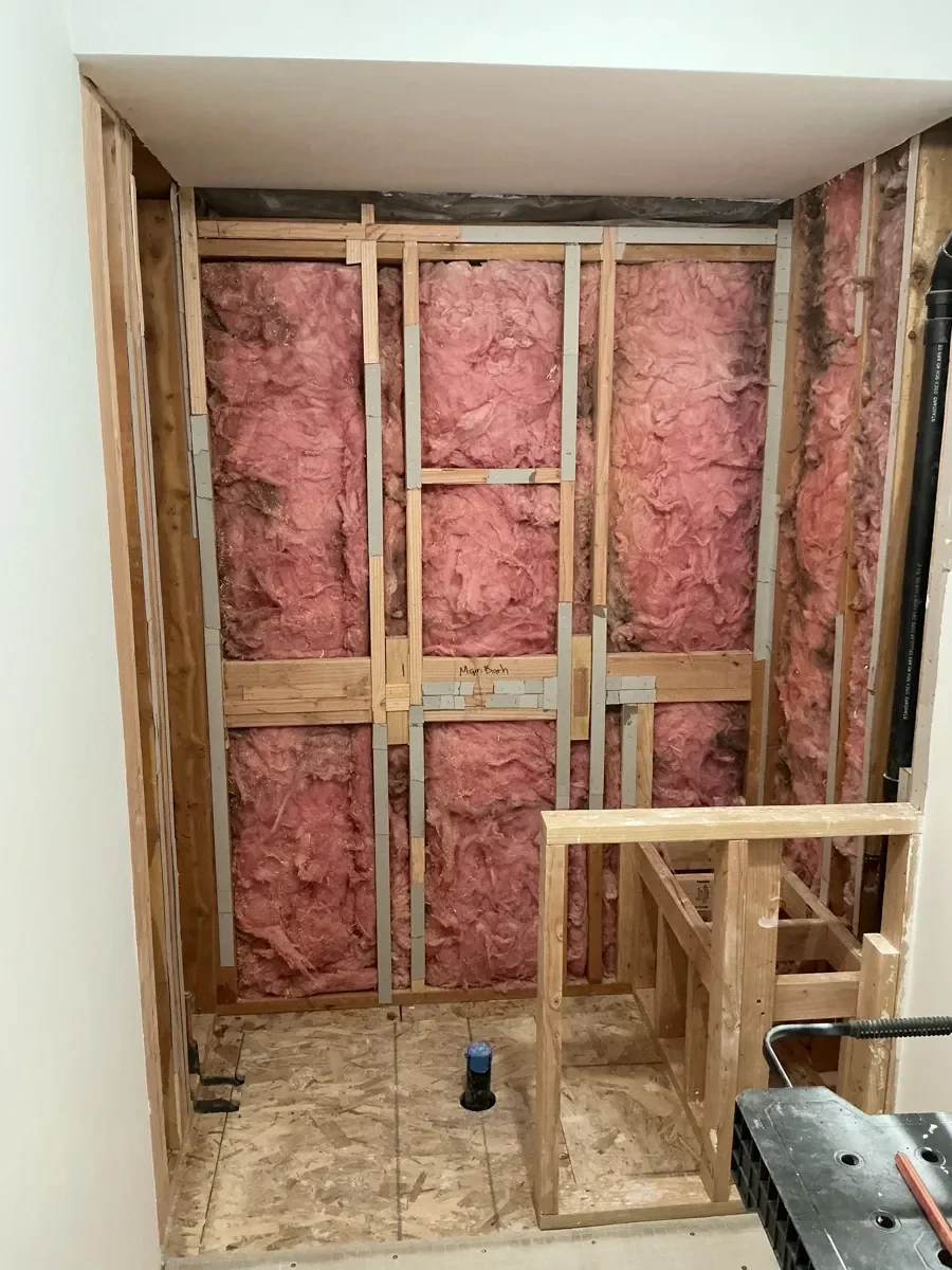 Progress photo of unfinished guest bathroom remodel in Gunbarrel, CO showing newly framed shower partition and shower bench frame