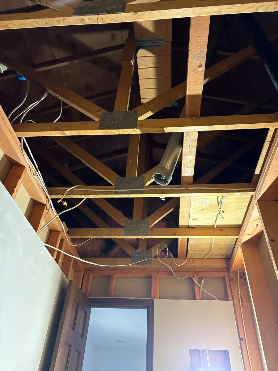 Boulder, CO bathroom remodel in progress featuring ceiling removal with exposed rafters making way for a 12 inch overhead expansion