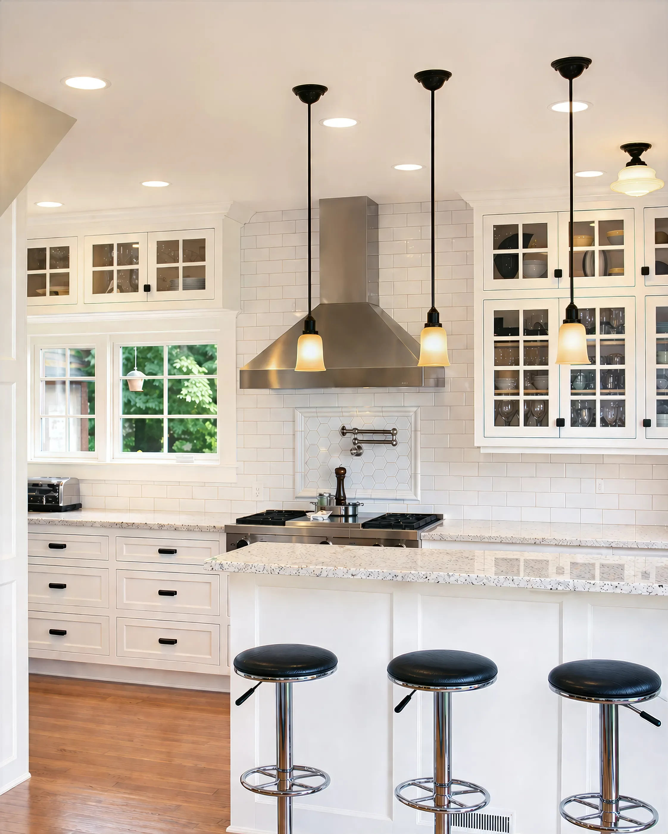 Overview of custom white inset cabinets, cherry hardwood floors, and stainless steel stove range and hood with mounted pot filler in a Boulder, CO contemporary farmhouse kitchen remodel