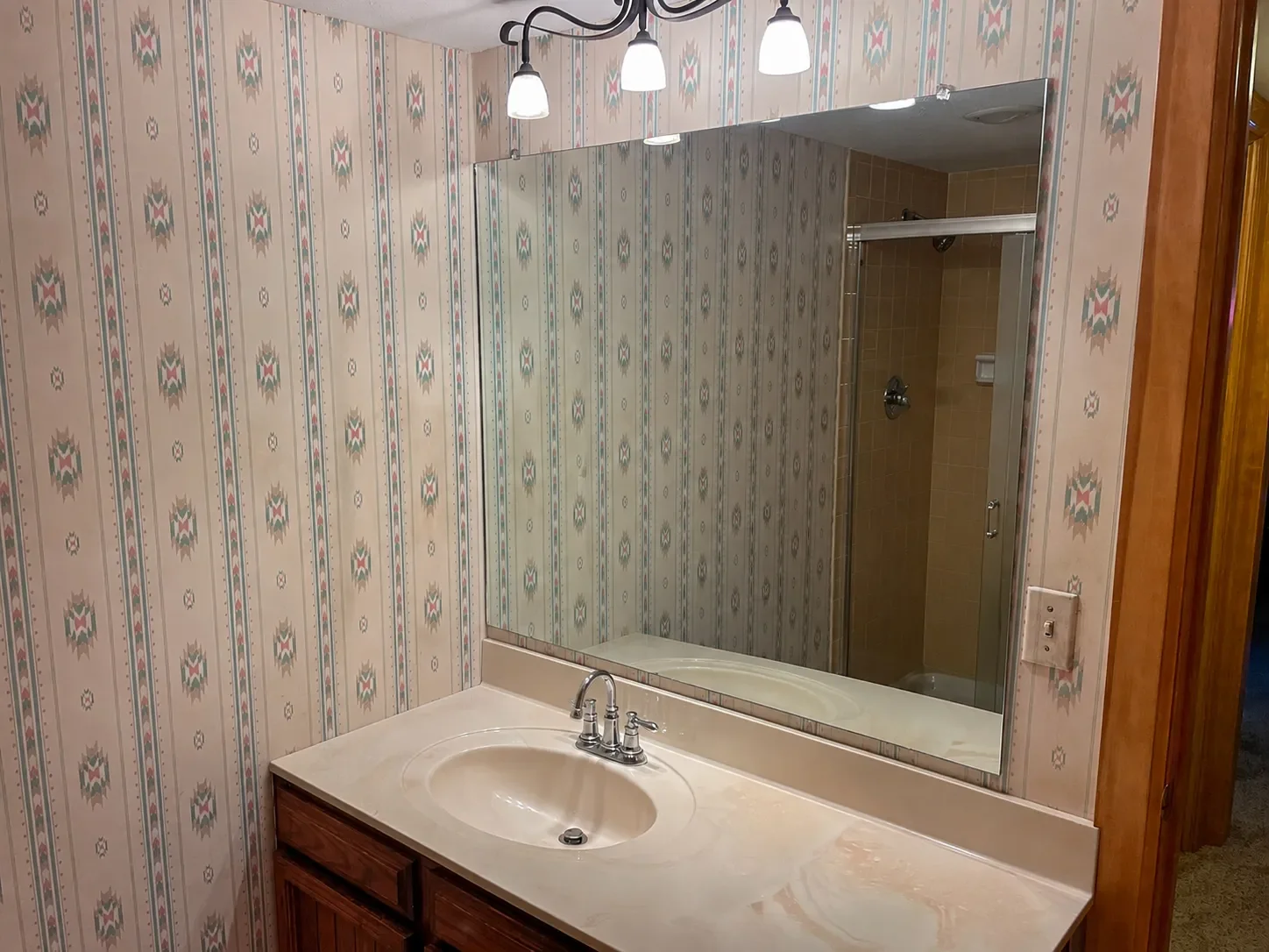 Niwot, CO vintage southwestern bathroom remodel before photo overlooking vanity with vintage wallpaper
