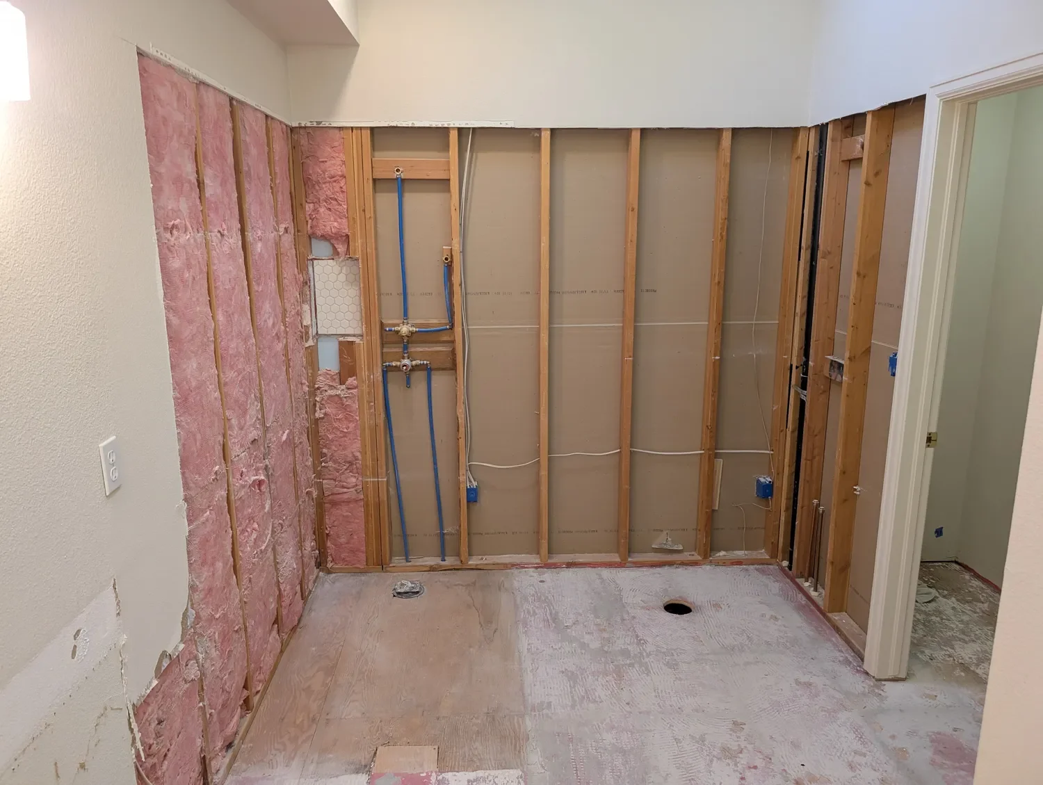 Renovation of master bathroom in Gunbarrel, CO home featuring wall framing, unfinished floors, and exposed insulation
