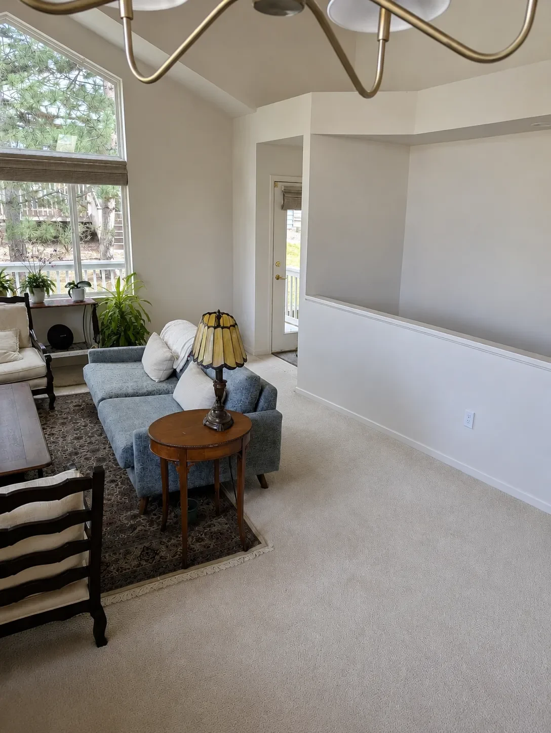 View of white carpeted living room in a Gunbarrel, CO home awaiting full interior remodel