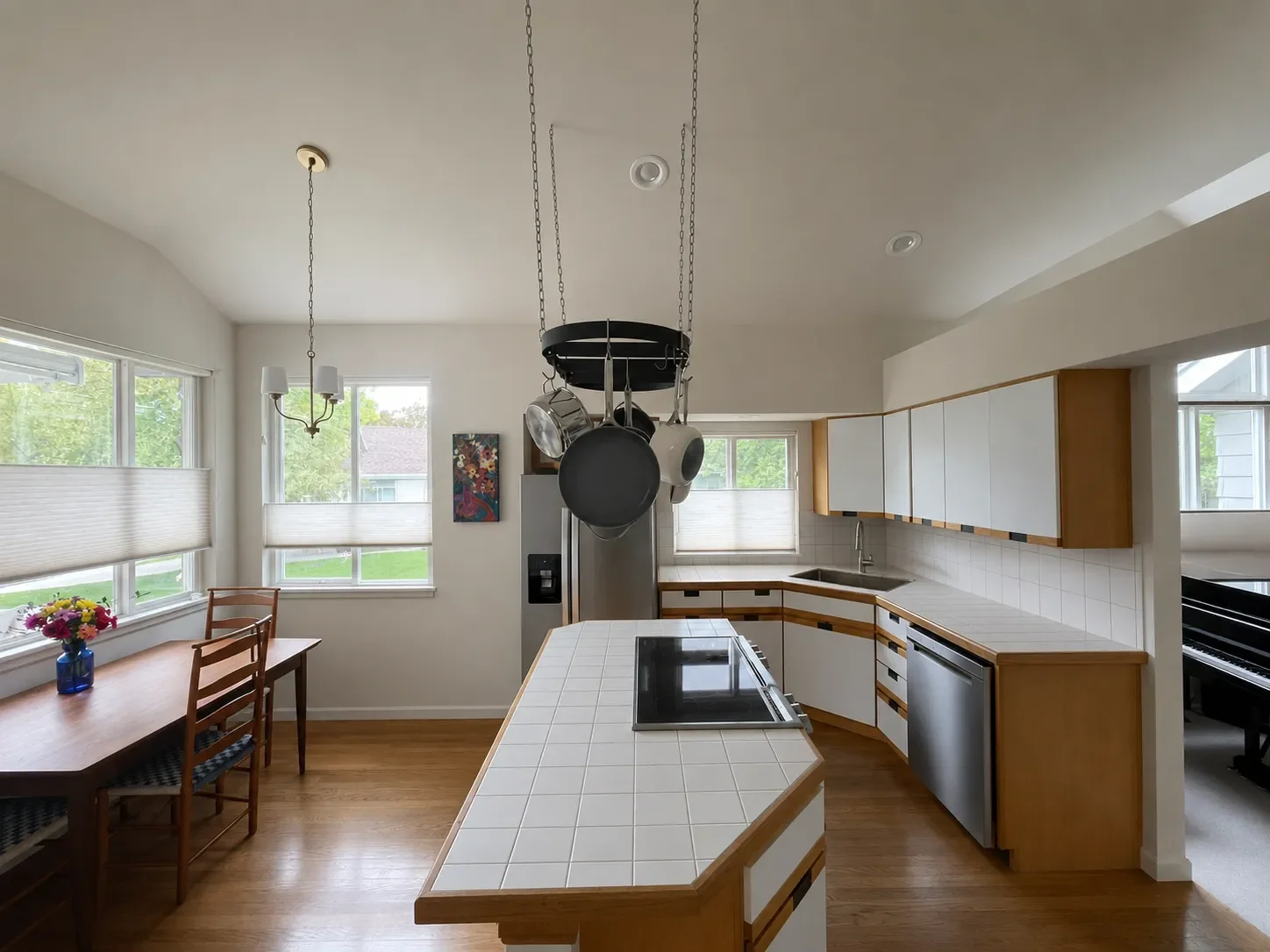 View of outdated kitchen before remodel with white tiled countertops, suboptimal appliance layout, and white laminate cabinet door panels in Gunbarrel, CO