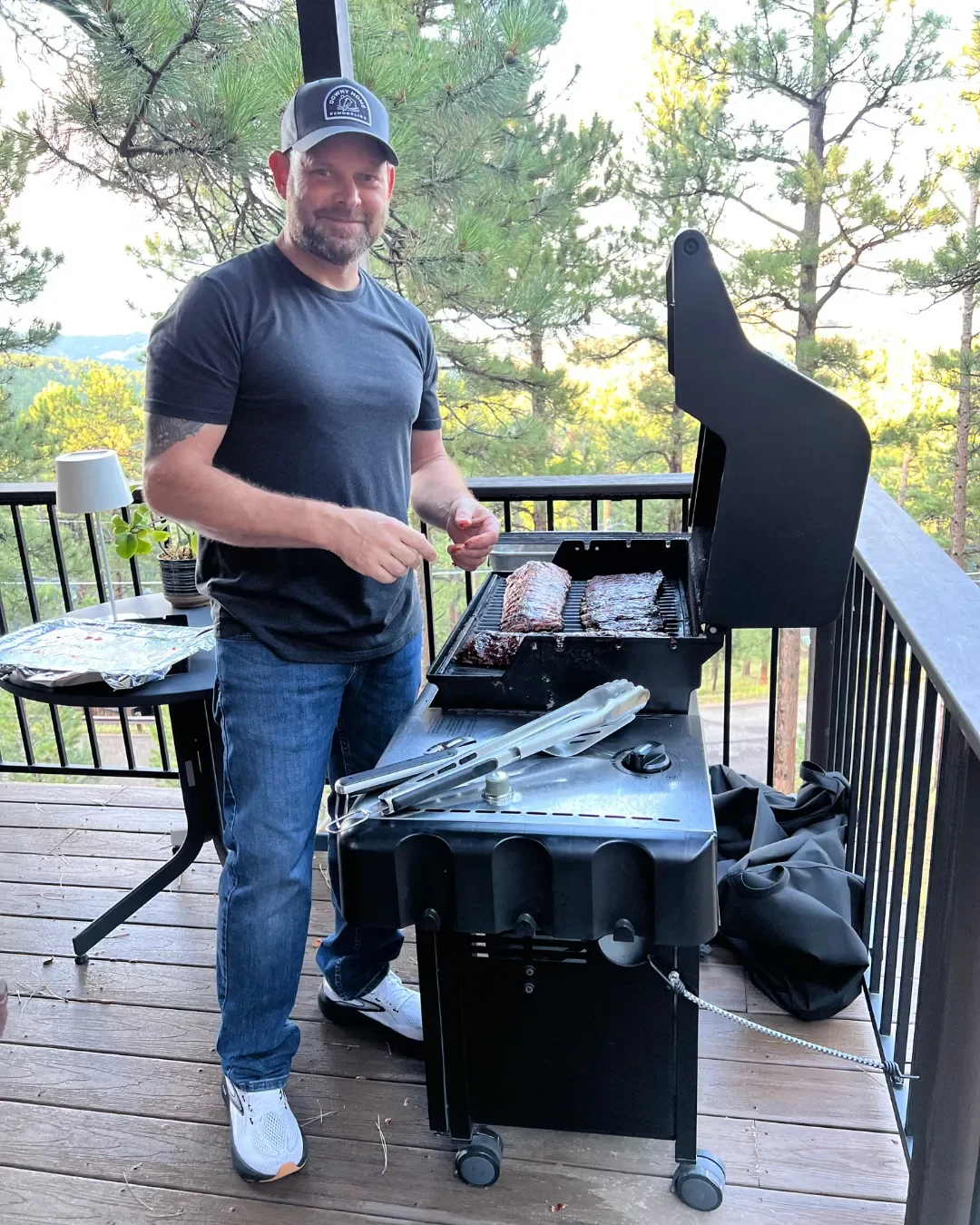Wayne Mullis, owner of Downy Home Remodeling, finishing smoked ribs on the grill at a bbq at a remodeling client's home in Boulder, CO