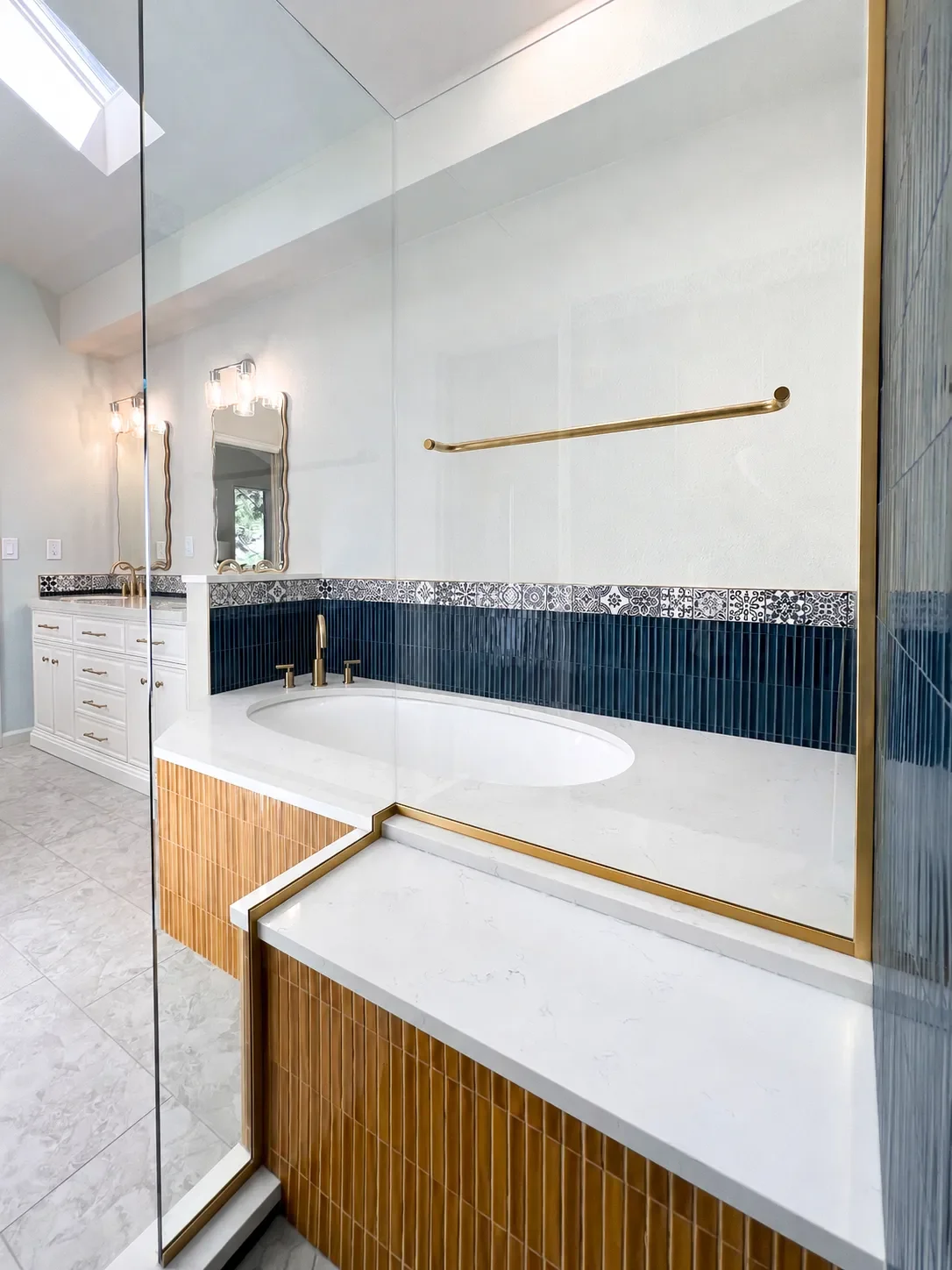 Gunbarrel, CO remodeled master bathroom featuring white quartz bathtub deck and shared shower benchtop, custom white double vanity with beveled edges, gray heated tile floors, and frameless glass walk-in shower