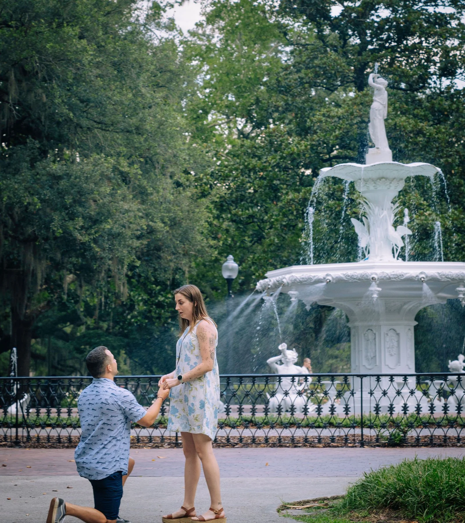 Forsyth fountain forsyth park in savannah ga man proposing to woman recently engaged couple on his knee.jpg