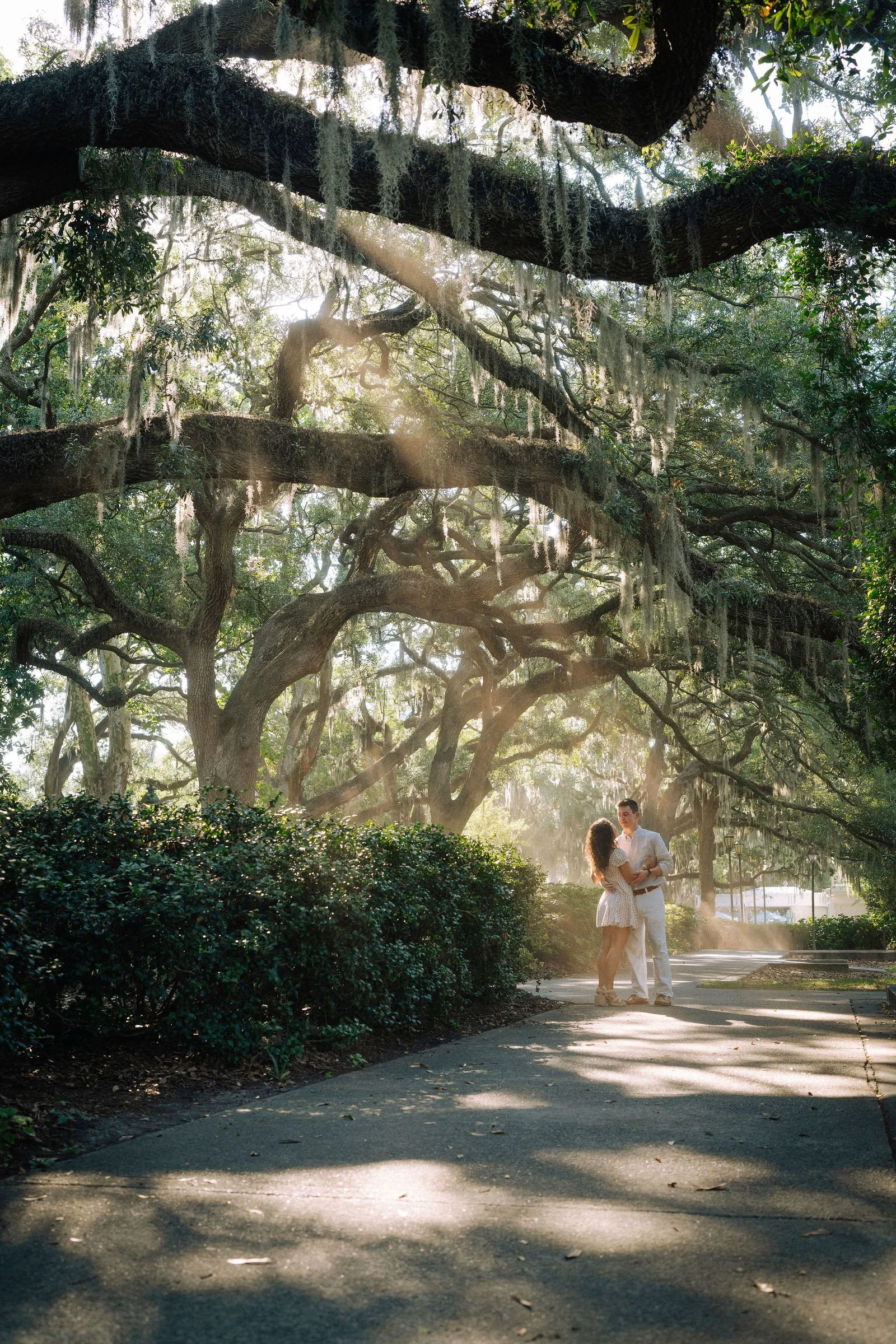 couple posing after getting engaged in forsyth park shade garden in savannah ga.jpg