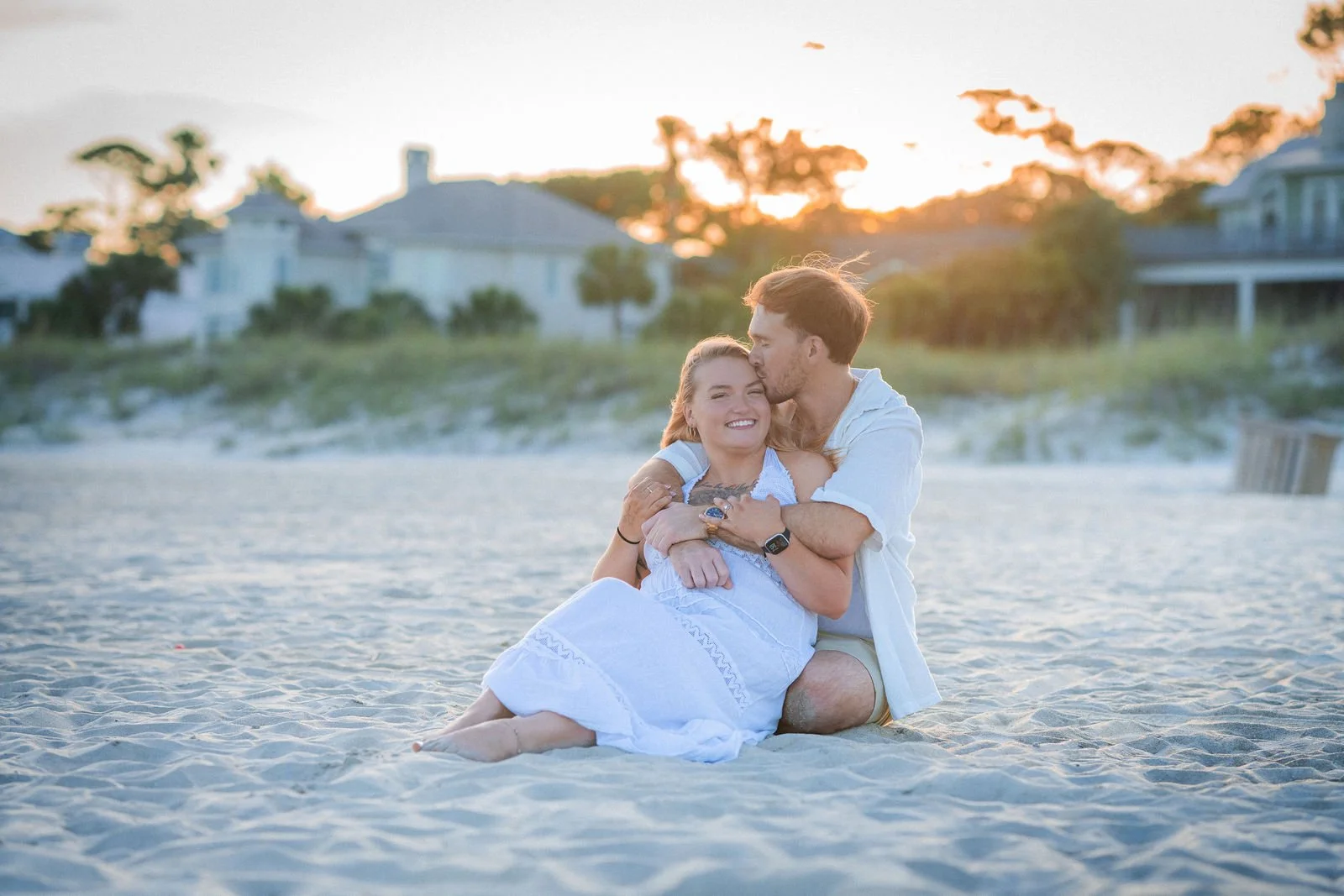 newly engaged couple sitting at beach in hilton head sc.jpg
