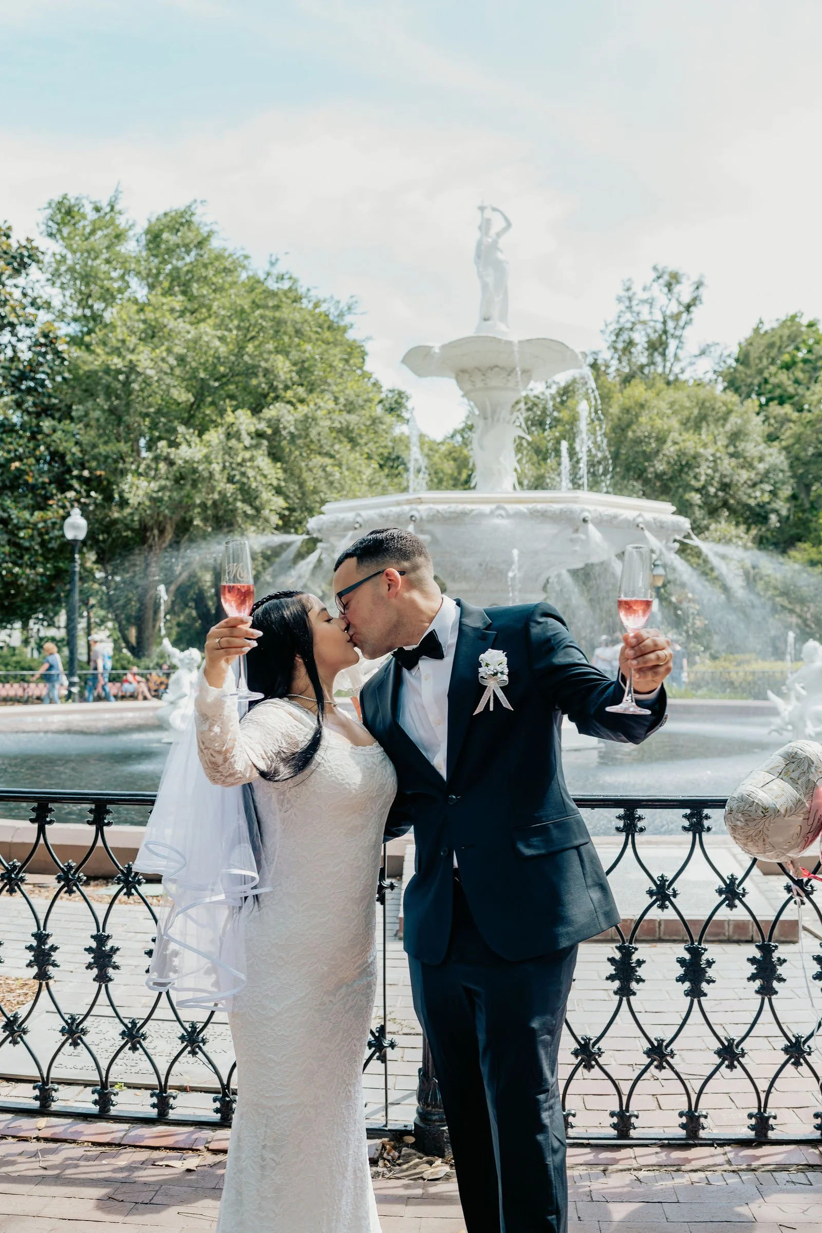 groom and bride toasting forsyth park fountain savannah ga.jpg