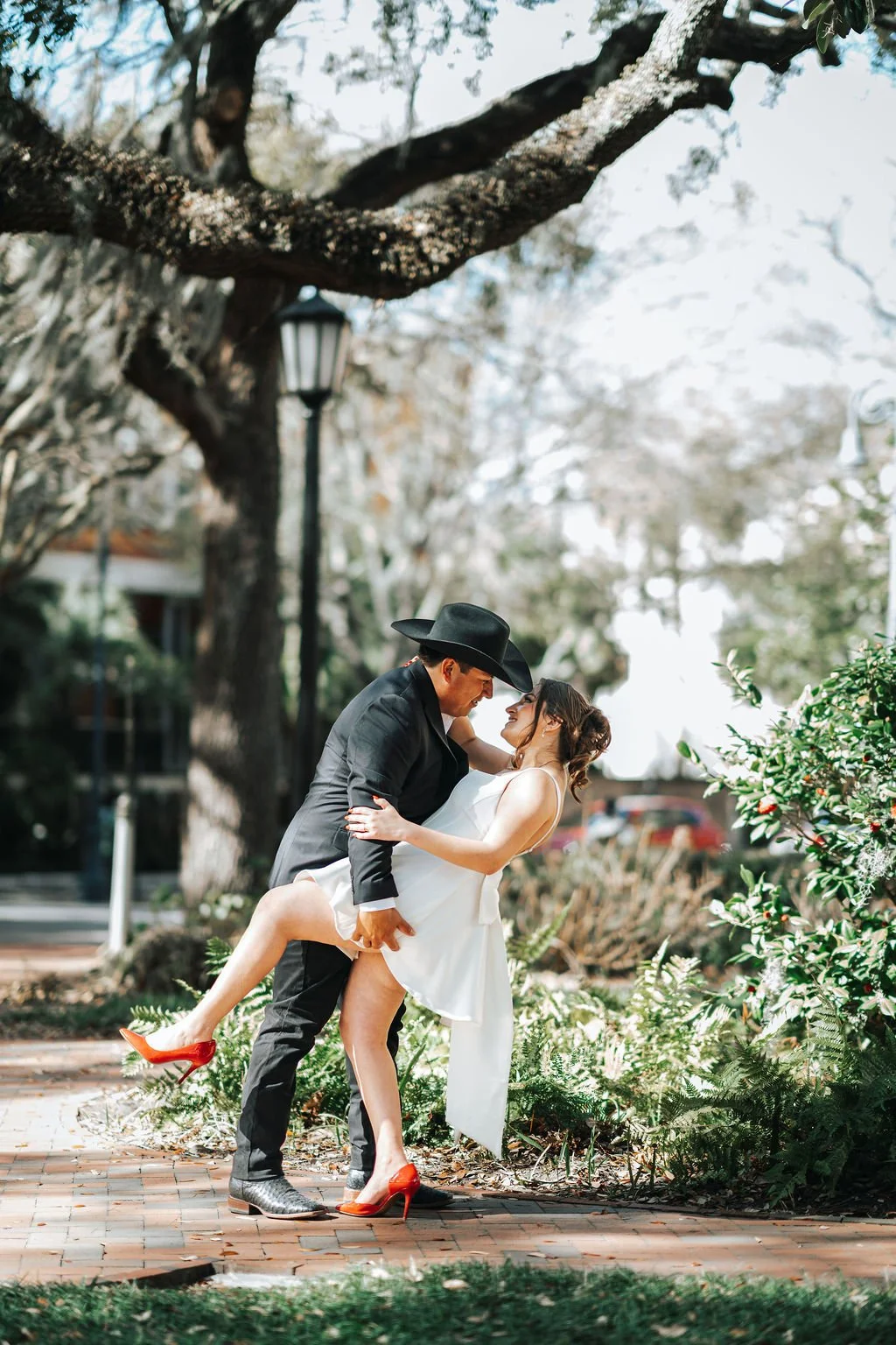 Savannah GA just married couple groom dipping bride romantic pose in historic square Savannah cinematic wedding photography by ARG Foto