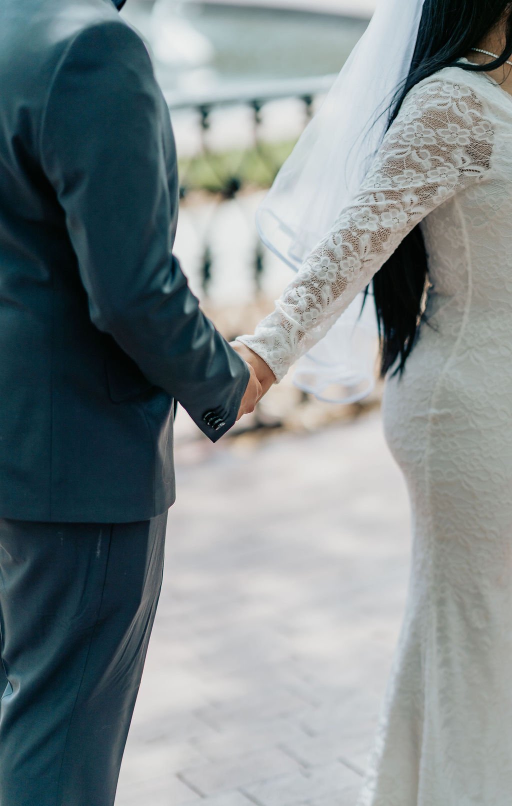 grooom and bride close up shot of their hand in forsyth park fountain in savannah ga under veil picture in savannah ga , wedding photographer in richmond hill GA by ARG Foto.