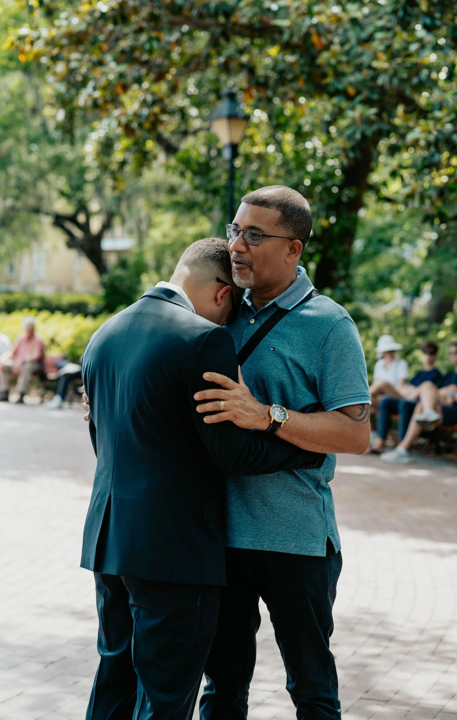 groom and father of the groom hug before ceremony forsyth park savannah ga wedding and elopement photographer.jpg