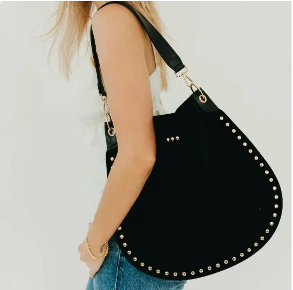 Your new go-to for spring 👜 Luxe texture, golden details, and a silhouette that goes with everything. This soft suede beauty is made to move with you.
⠀
✨ Gold rivet accents
🗝️ Interior with key leash, zip &amp; open pockets
🔁 Adjustable + removab