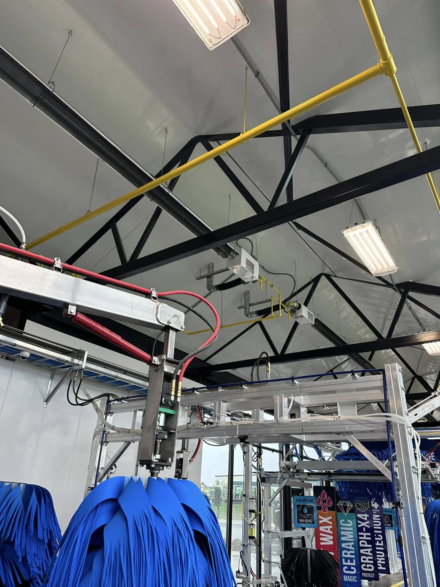 Industrial water park with blue plastic inflatable slides and a metal frame structure.