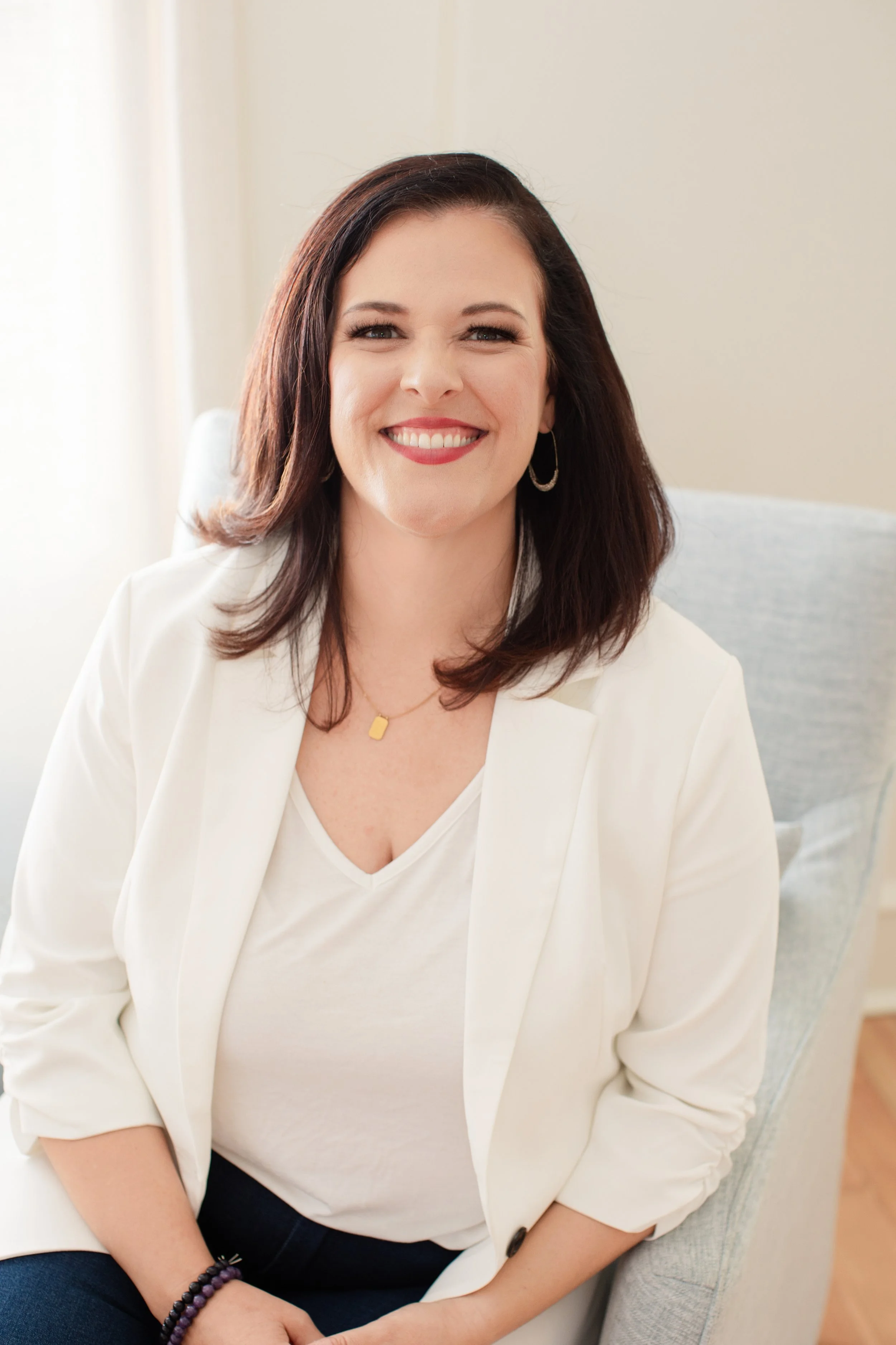 emma mulvany, empowerment mentor, sitting on chair, smiling