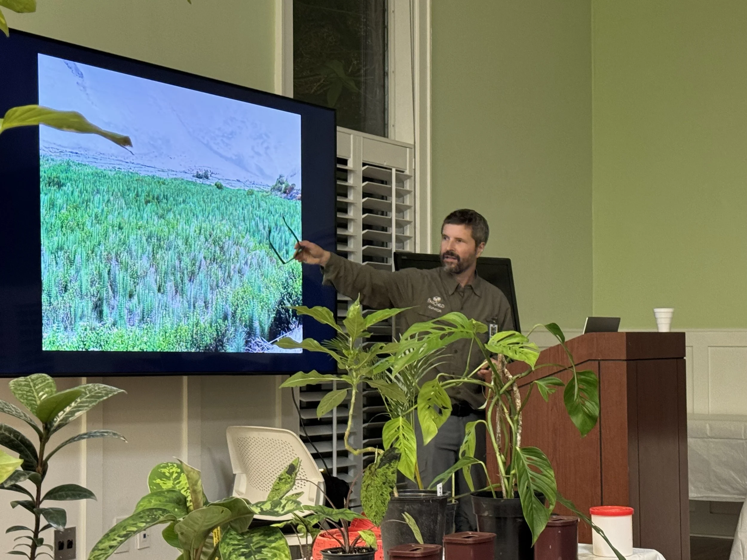 Chad Husby pointing toward an image of a field of horsetails.