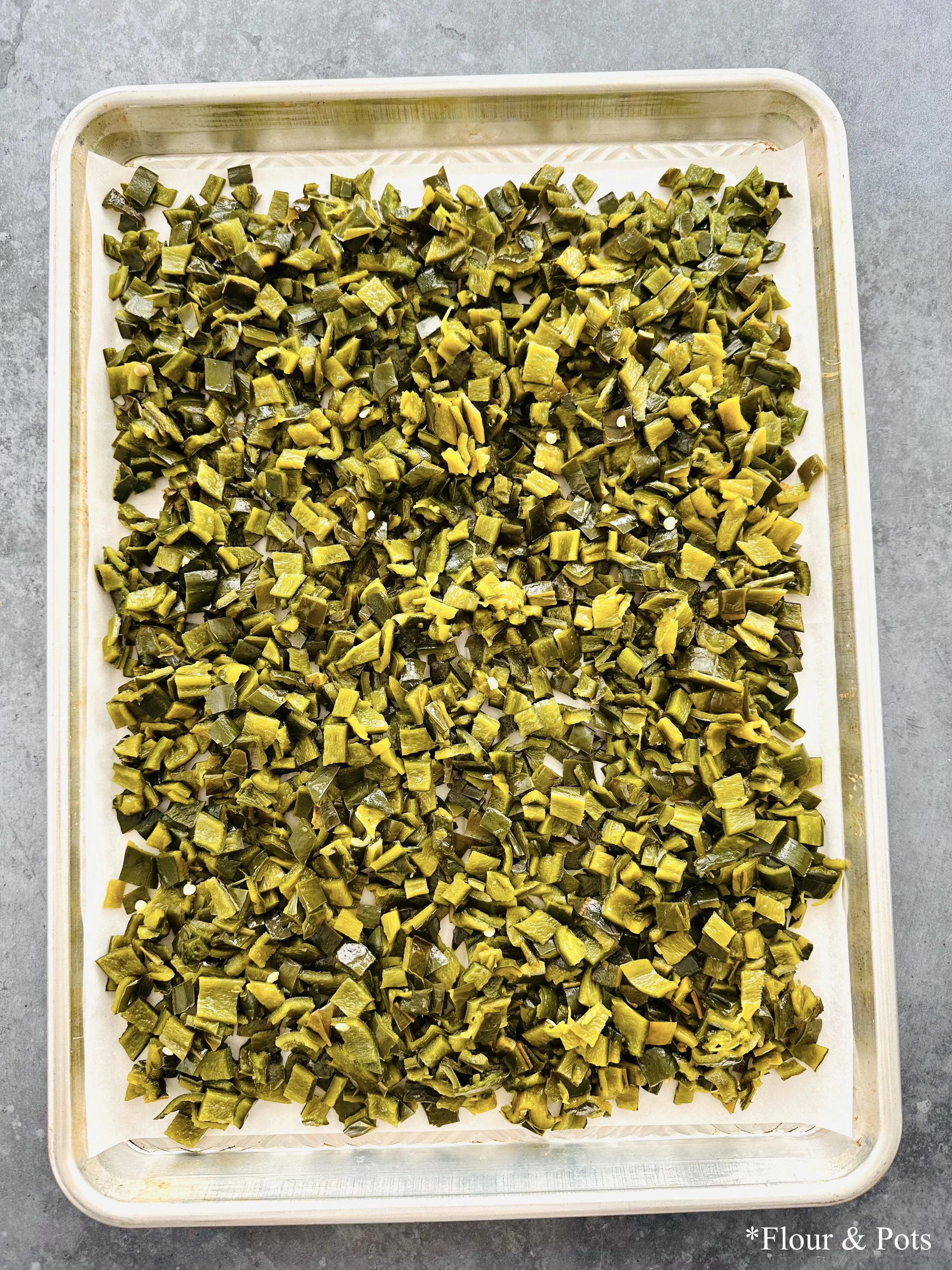 Sheet pan with roasted poblano peppers cut into chunks, ready to use in recipes.