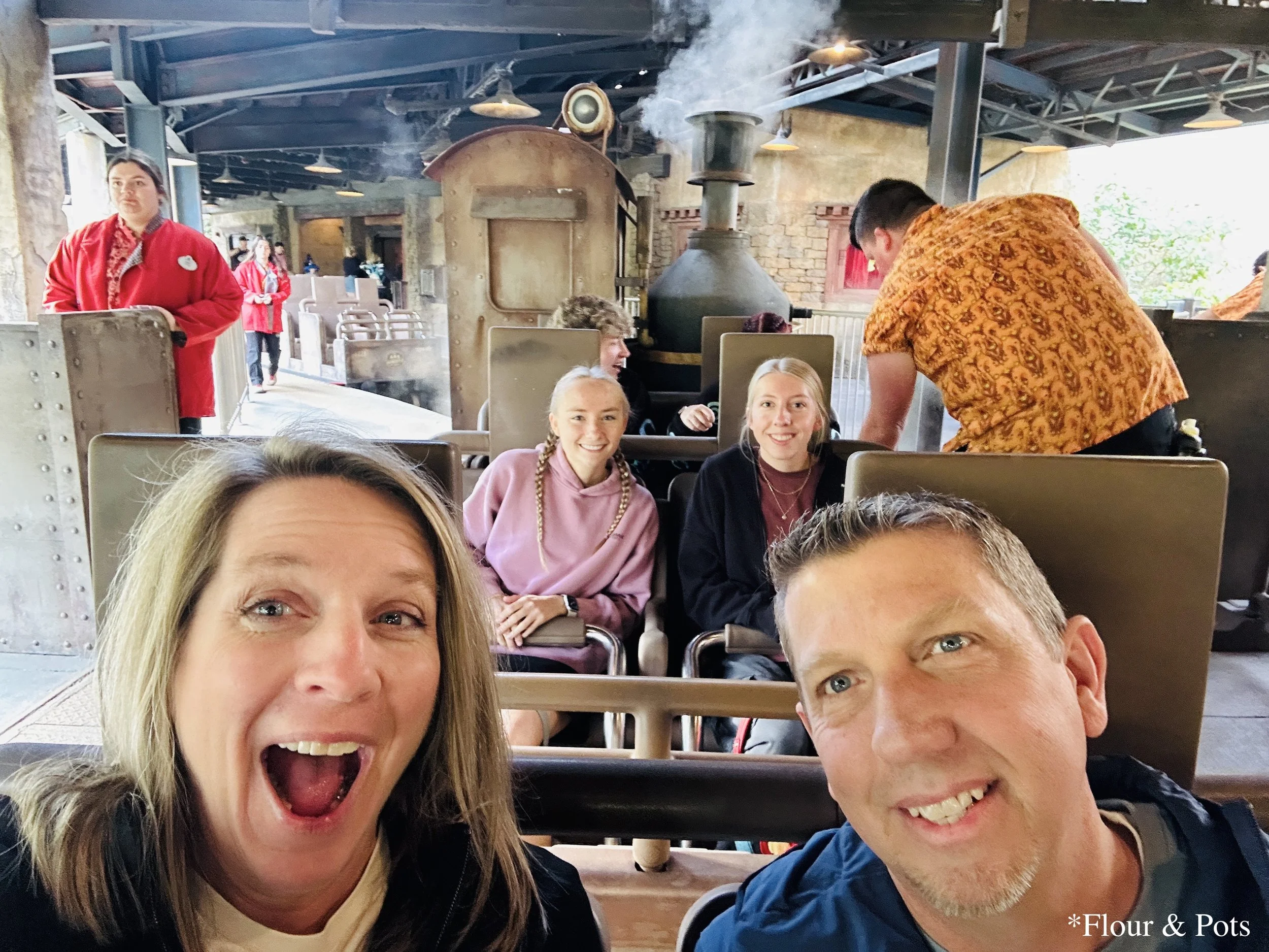 Family members smiling and waiting in carts to ride Expedition Everest at Disney's Animal Kingdom in Orlando, Florida