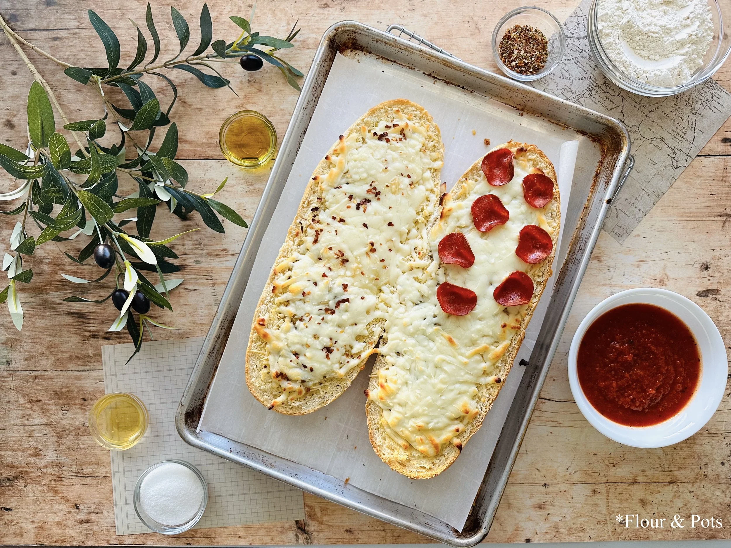 Golden French bread pizza with gooey cheese, sprinkled with dried herbs, fresh from the oven.