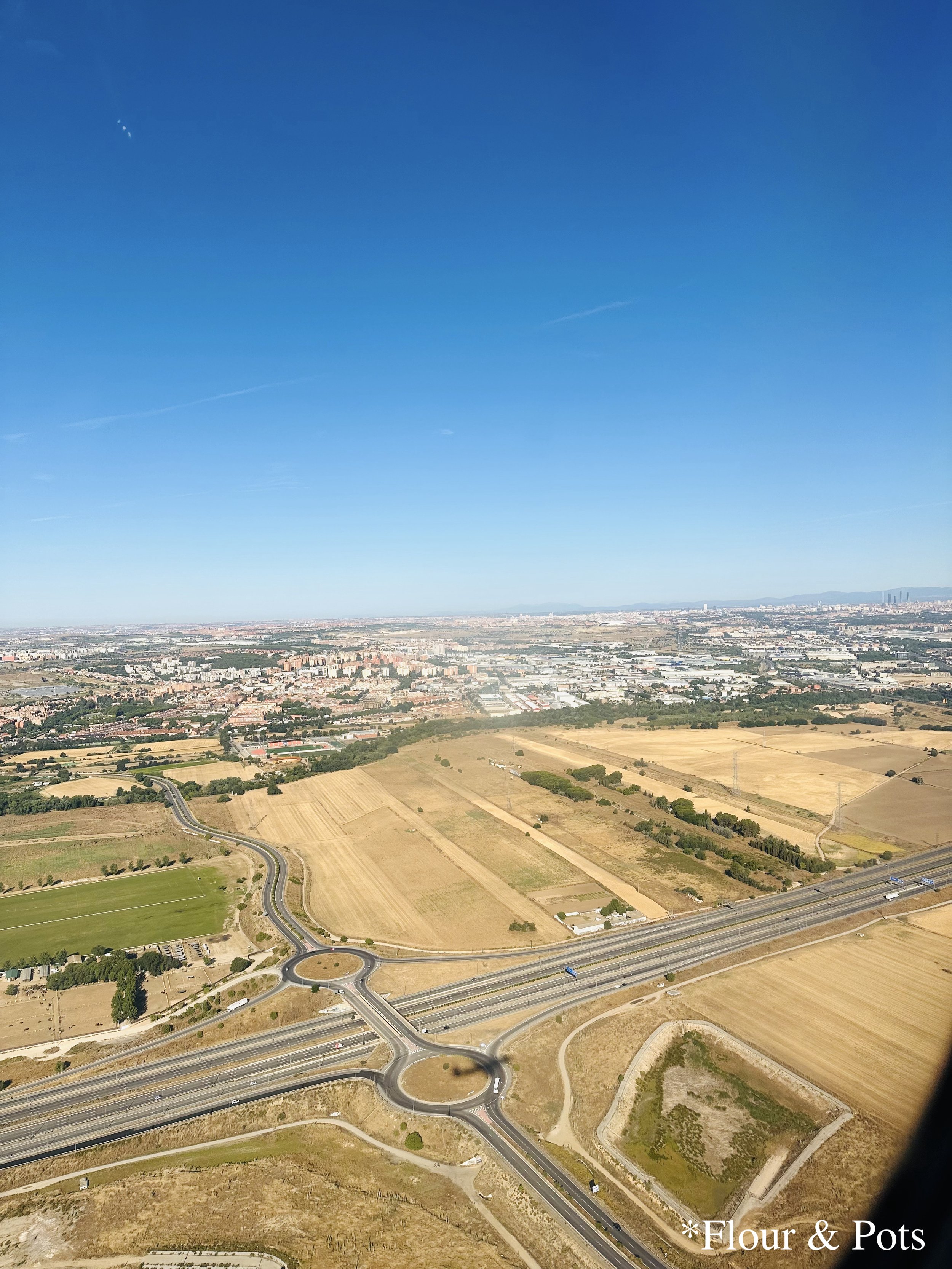 View from the airplane as it approaches Madrid, showing dry, parched fields beneath the summer heat, taken during the flight from ORY to MAD.