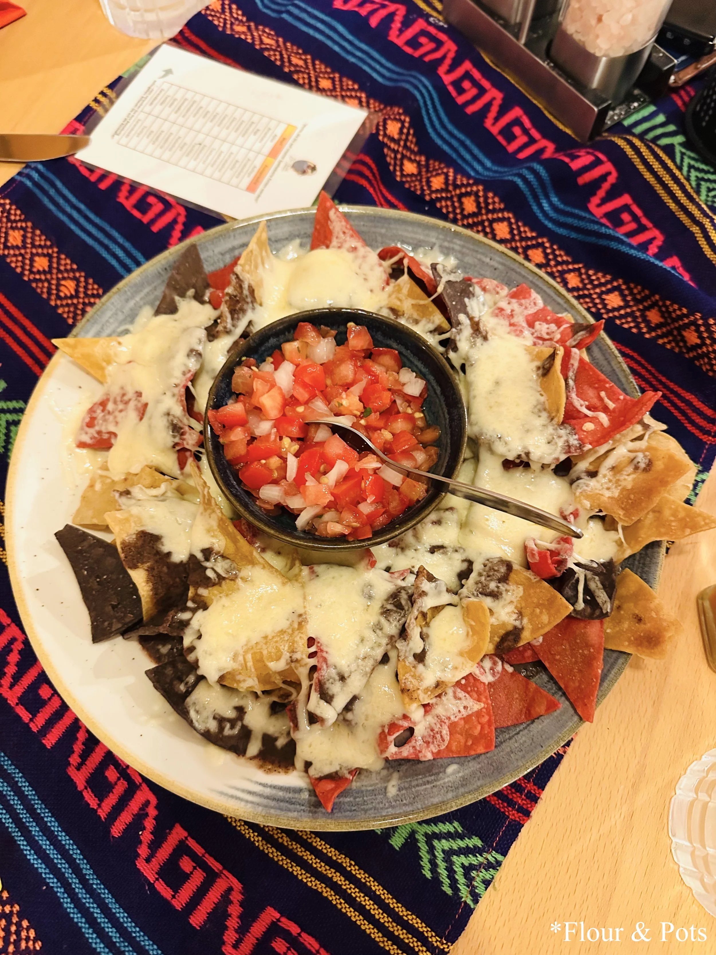 Plate of nachos served at Restaurant Don Gallo in Rothenburg, Germany, with cheese and a side of salsa for dipping.