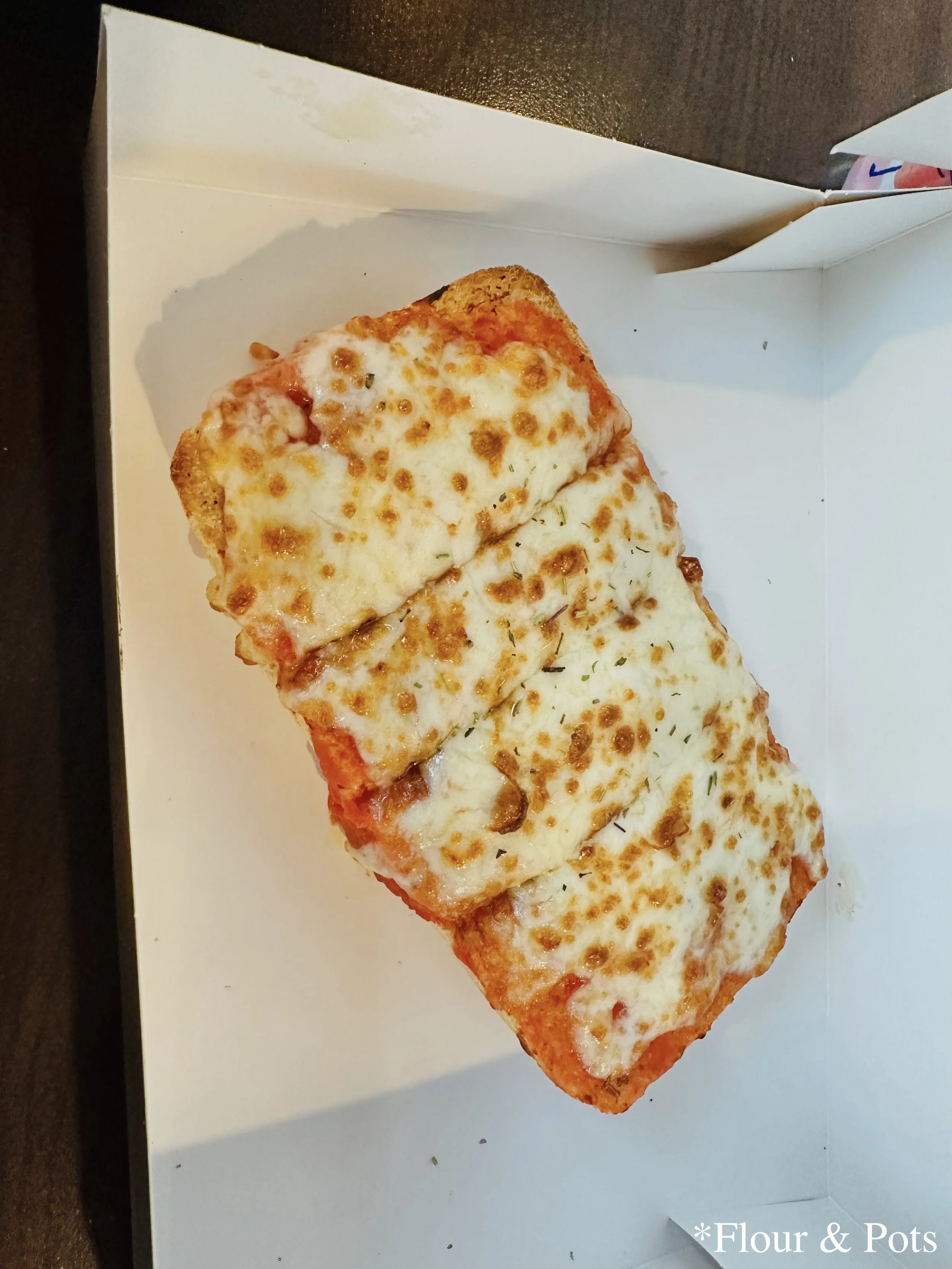 id’s cheese pizza with marinara sauce on a bread bun from Earl of Sandwich in Disney Village near Disneyland Paris, France.