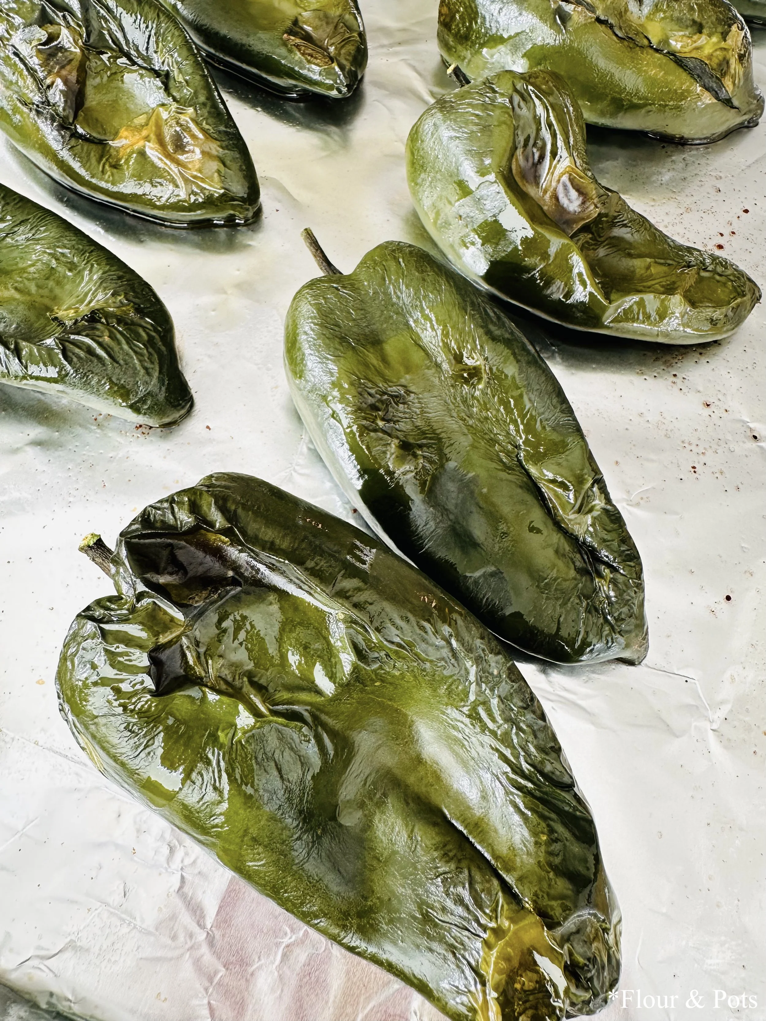 Roasted poblano peppers just out of the oven, with blistered skins and deep color.