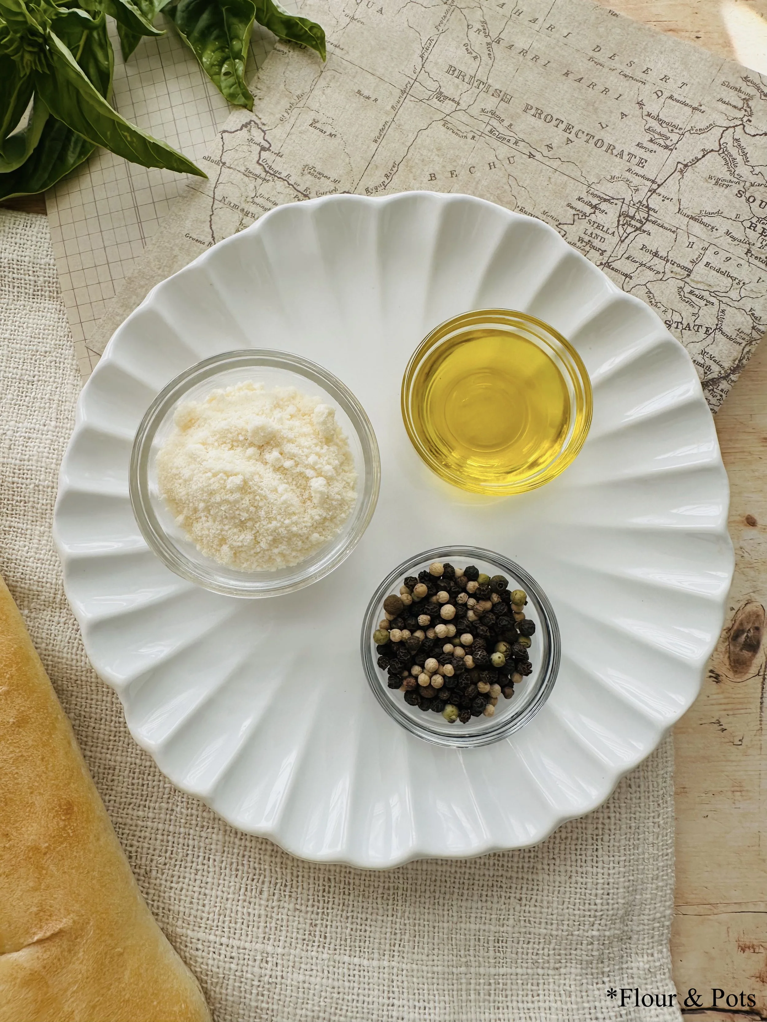 Cacio e Pepe French bread ingredients, including olive oil, black pepper, and freshly grated Parmesan cheese.
