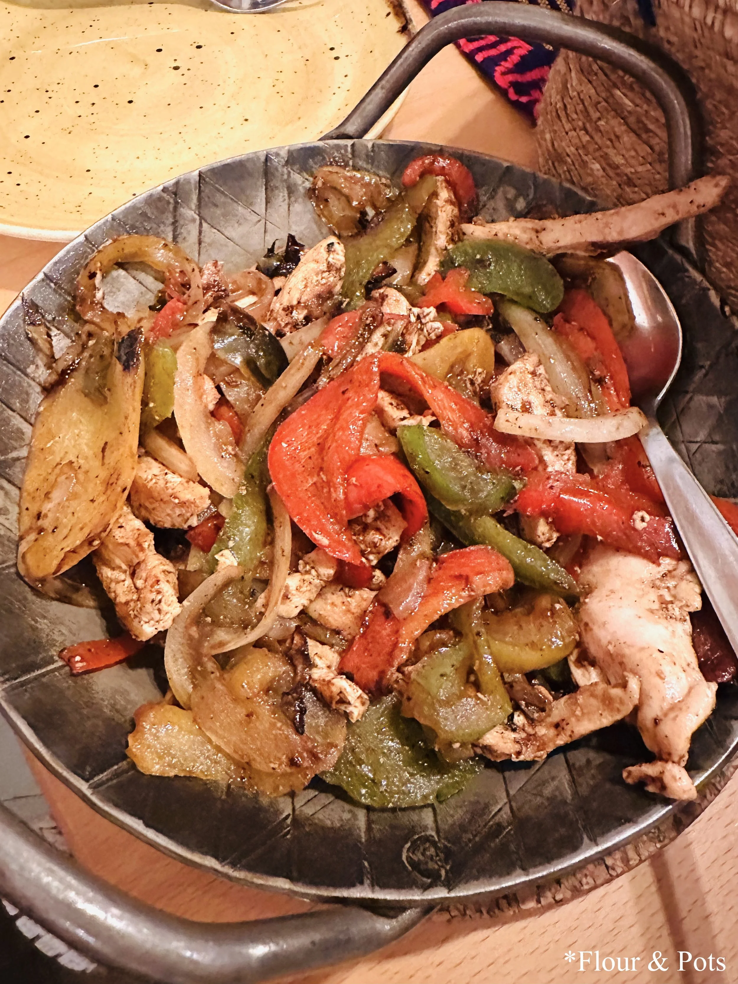 Chicken fajitas served at Restaurant Don Gallo in Rothenburg, Germany, with sizzling chicken, bell peppers, onions, and warm flour tortillas on the side.
